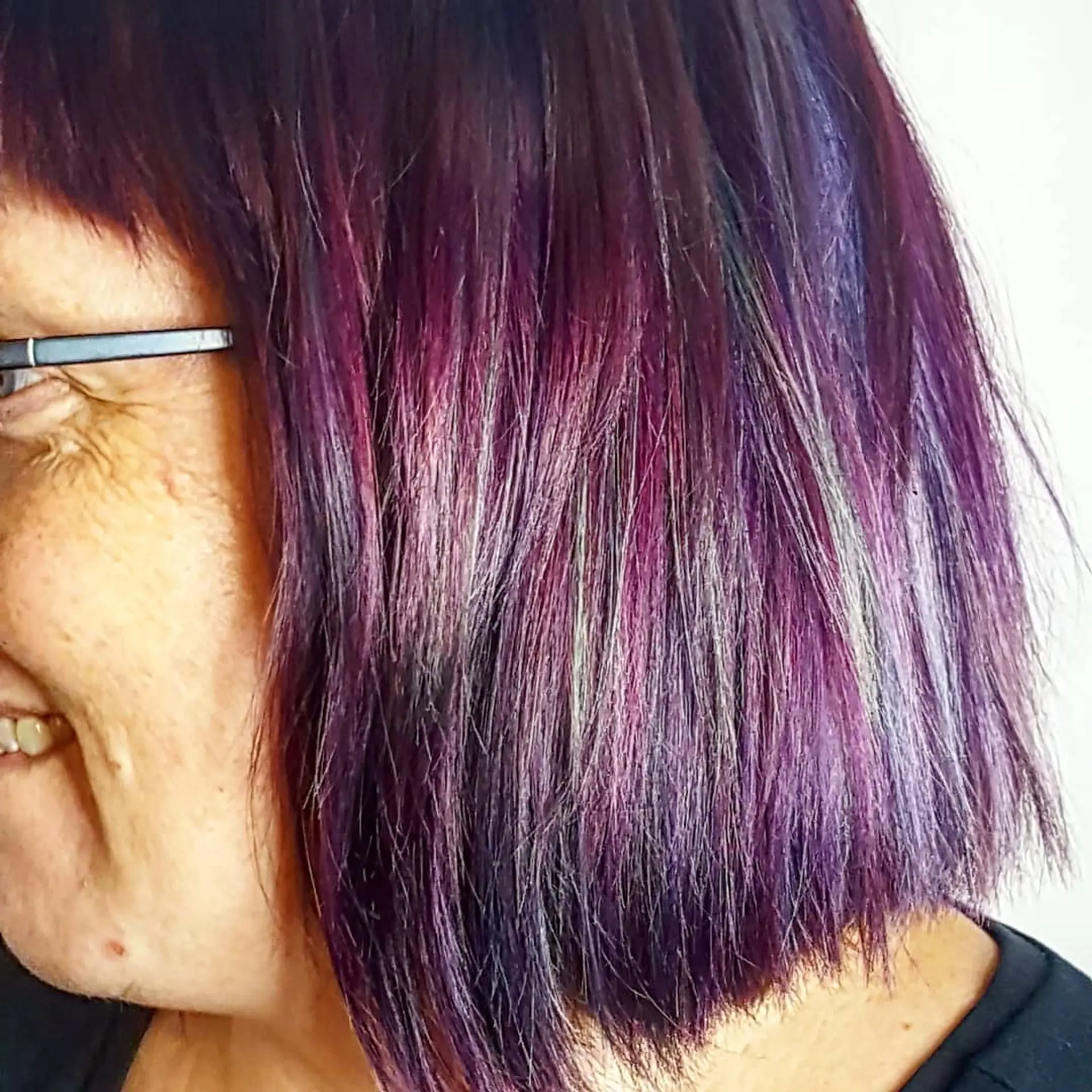 A textured chin-length bob colored in vibrant violet-purple with subtle turquoise highlights. 1