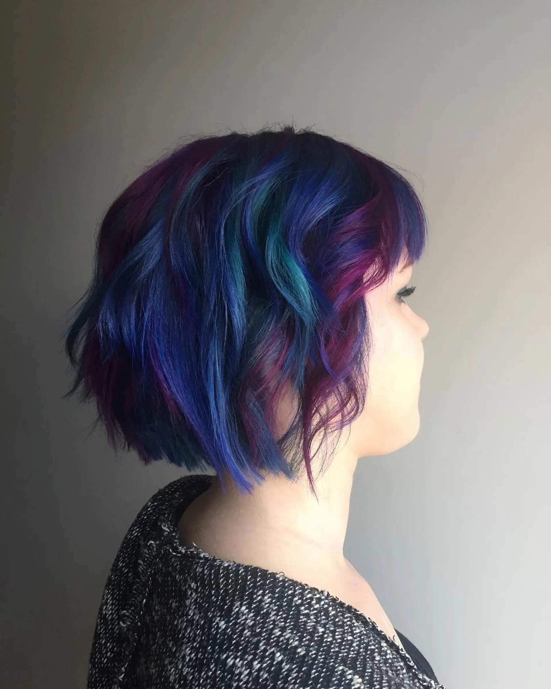 A short, wavy bob with vibrant blue, purple, and teal colors. 1
