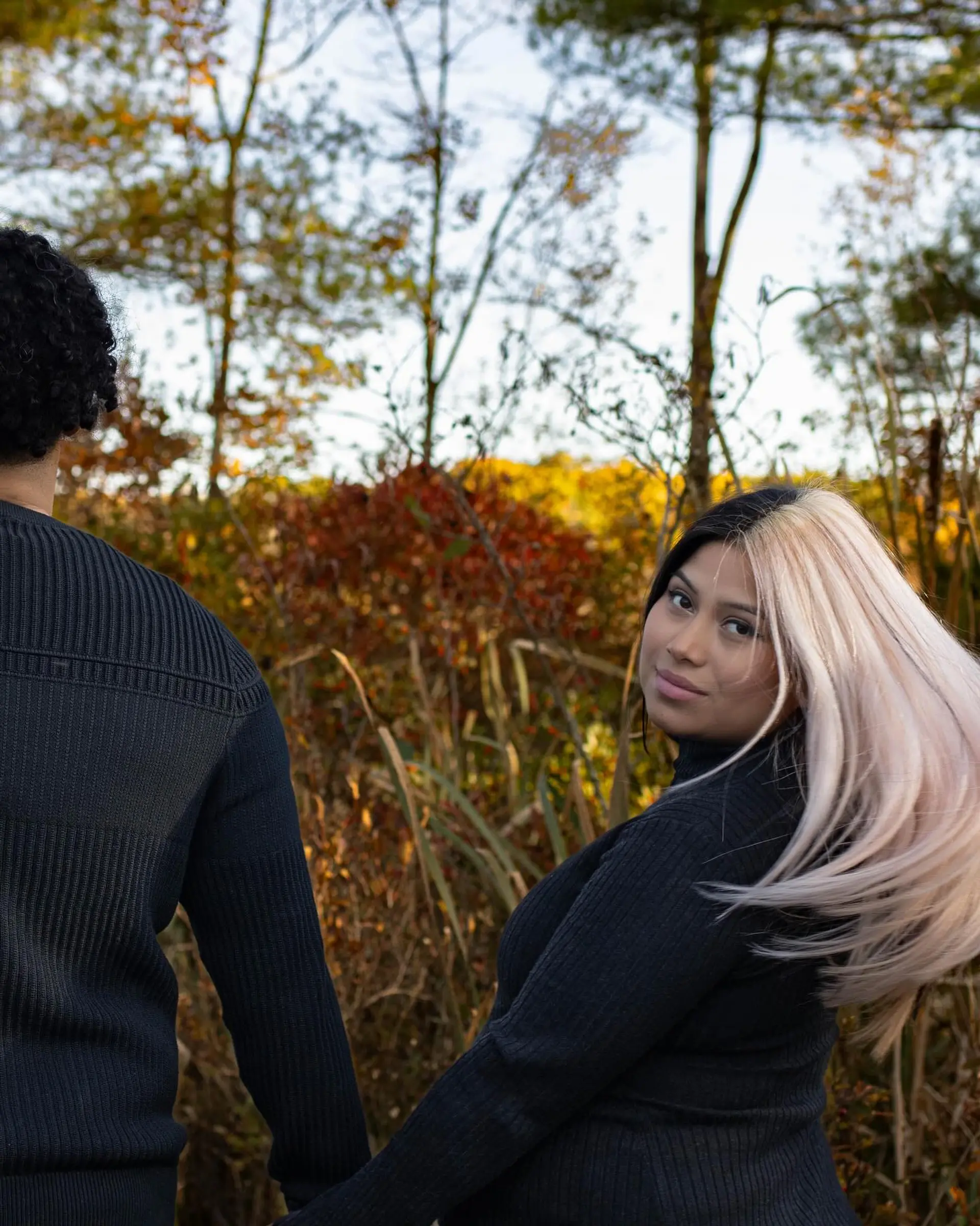 A striking split dye hairstyle featuring jet black on one side and platinum blonde on the other, styled smooth and straight. 1