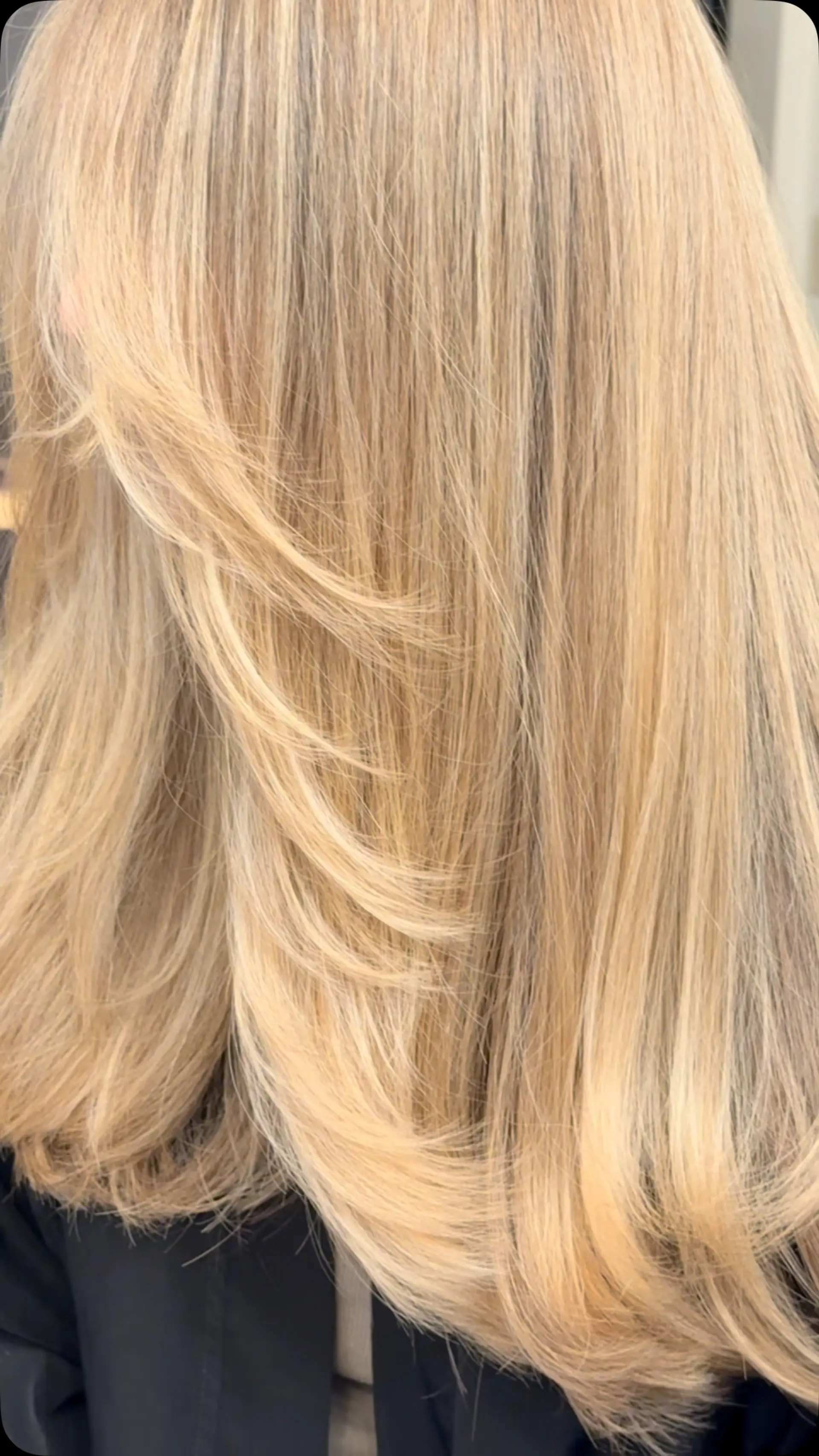 A warm golden blonde blowout styled with soft face-framing layers and flipped-under ends. 1