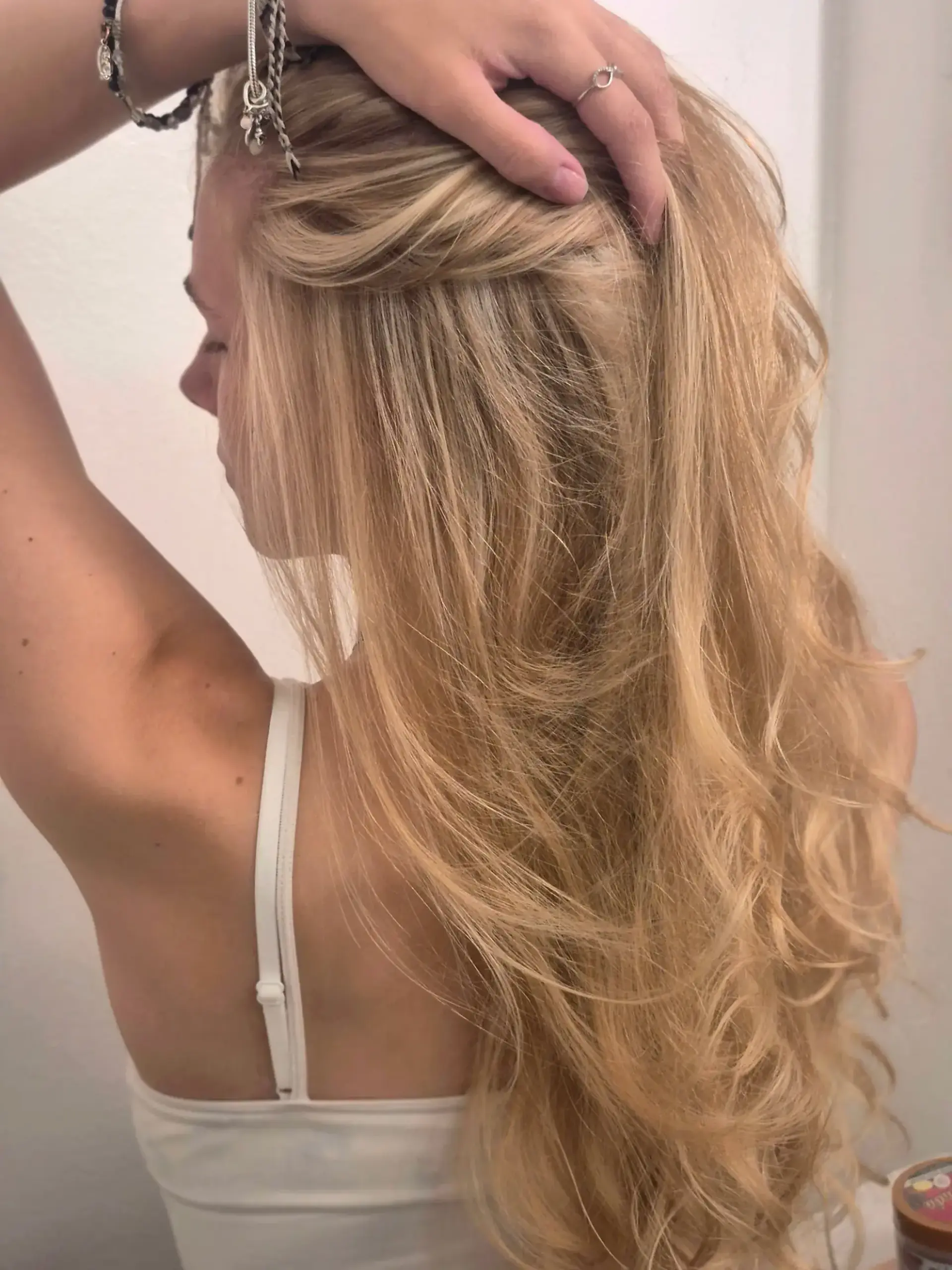 Long layered warm blonde hair styled with soft, voluminous curls and multi-dimensional highlights. 1
