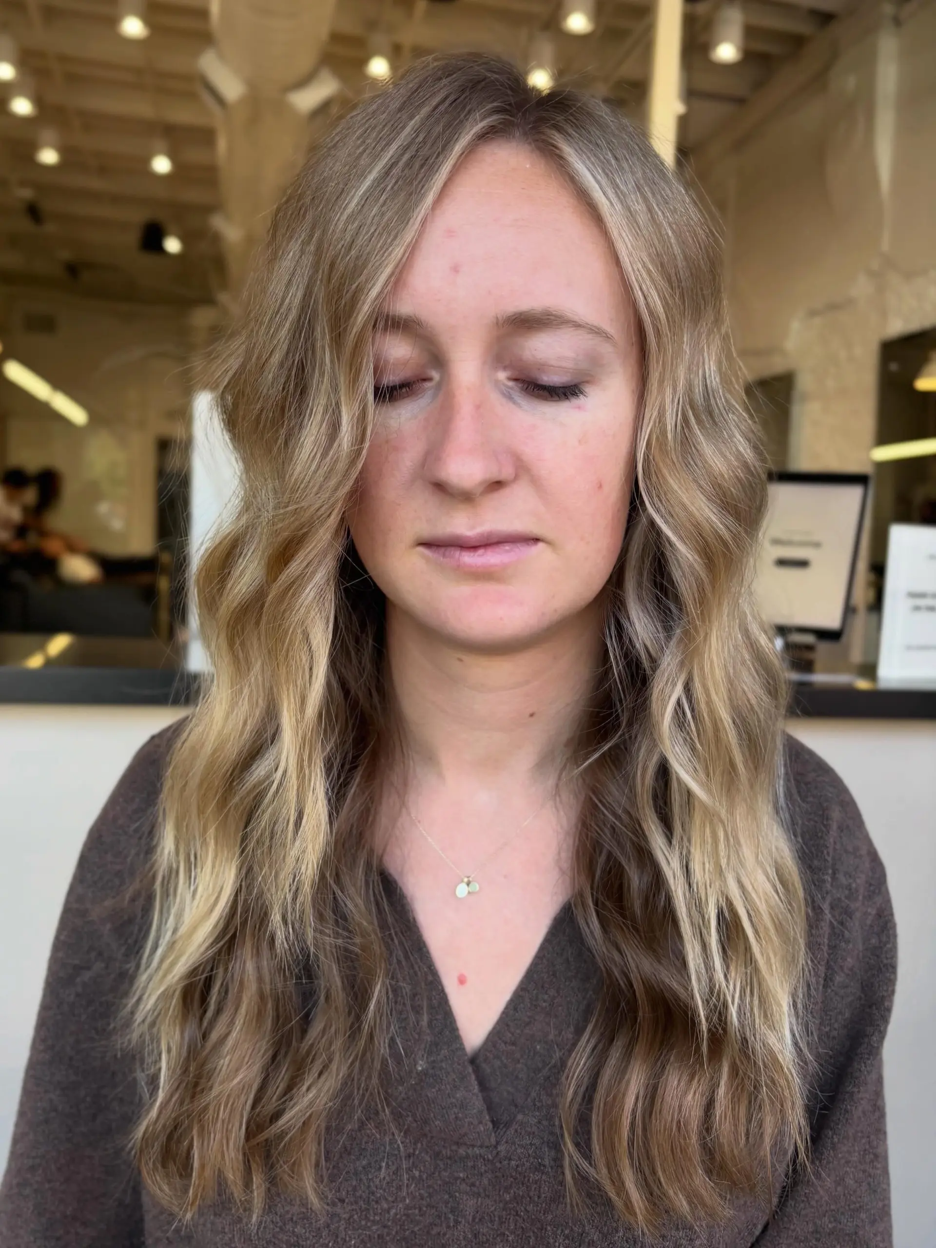 Long lived-in blonde hair styled in soft, loose waves with face-framing lightness. 1