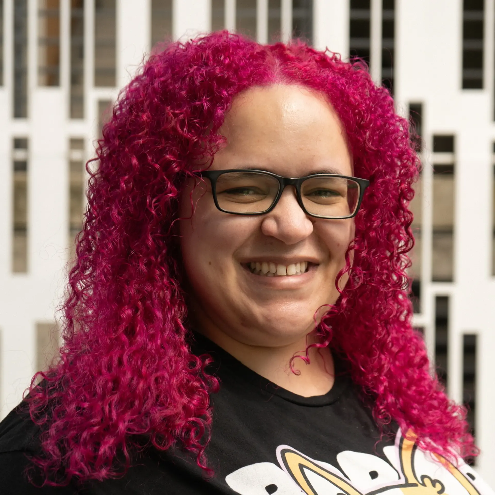 Medium-length defined curly ringlets styled with natural volume and dyed in a vivid, high-saturation magenta and fuchsia tone. 1