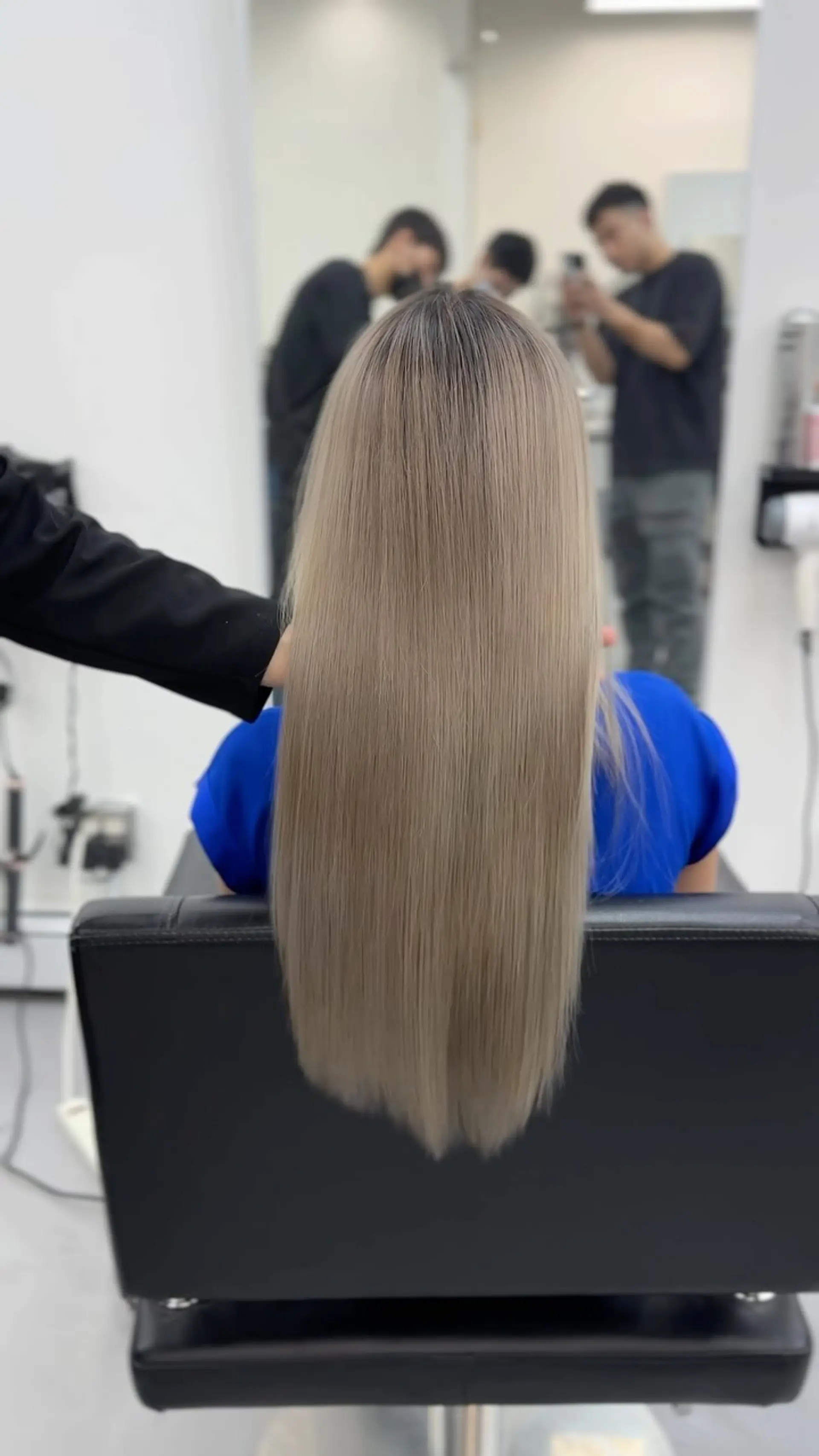Long, ultra-straight hair featuring a cool-toned ash blonde balayage with a dark shadow root. 1