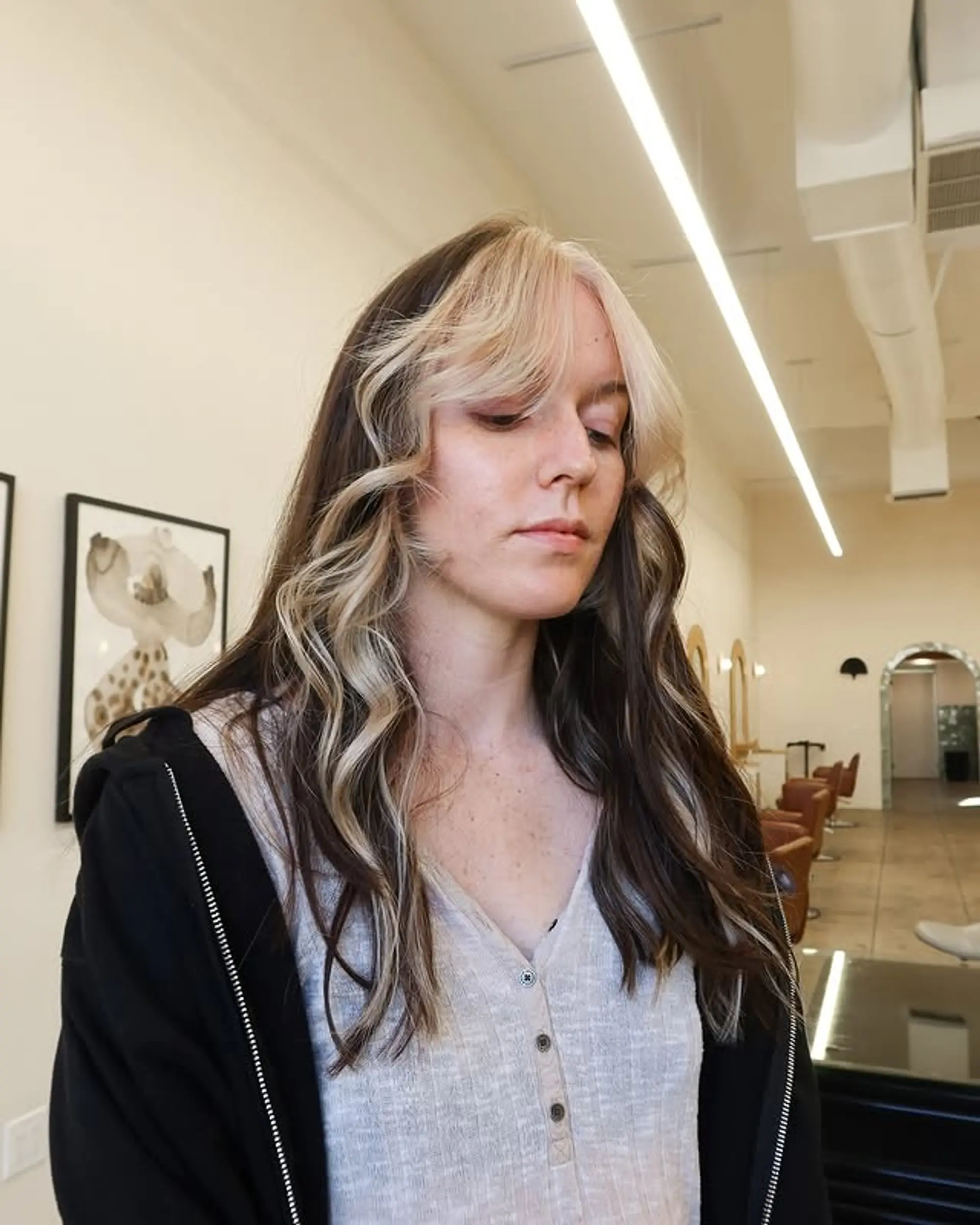 Long wavy hair with face-framing chunky highlights and curtain bangs. 1