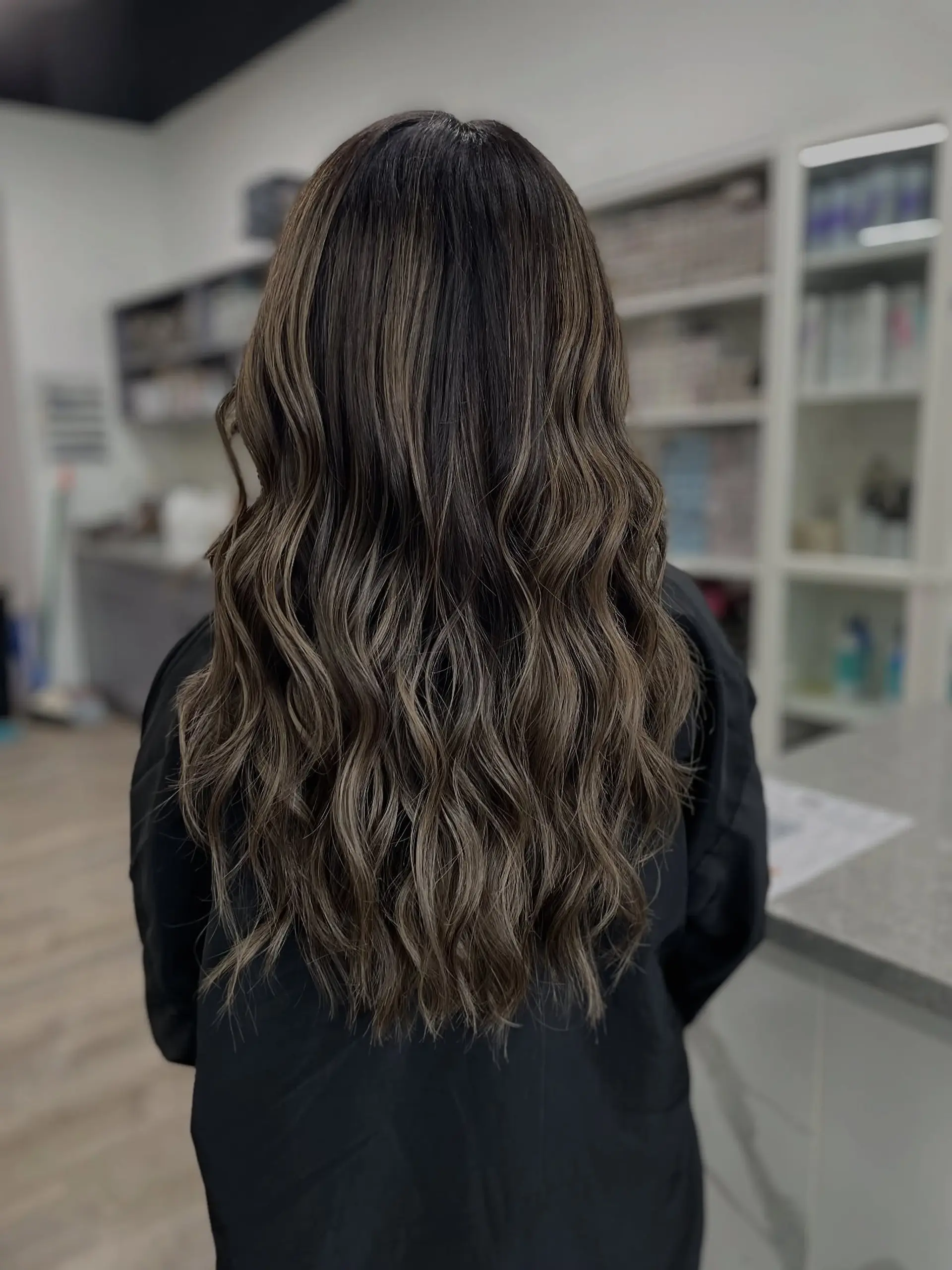 Long, wavy bronde hair styled with a balayage technique. 1