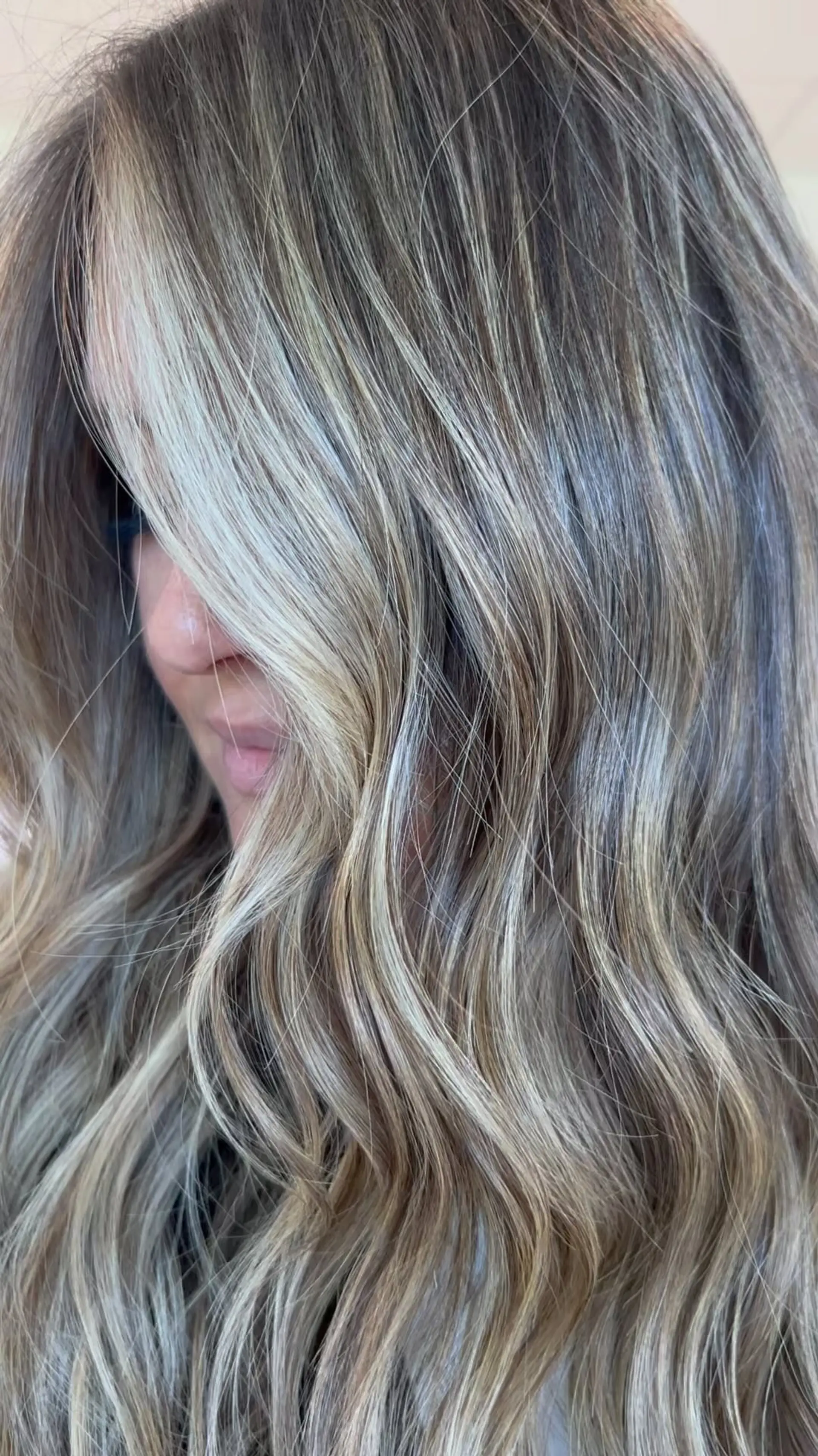 Long wavy hair featuring seamless, bright dimensional blonde highlights over a cool light brown base. 1