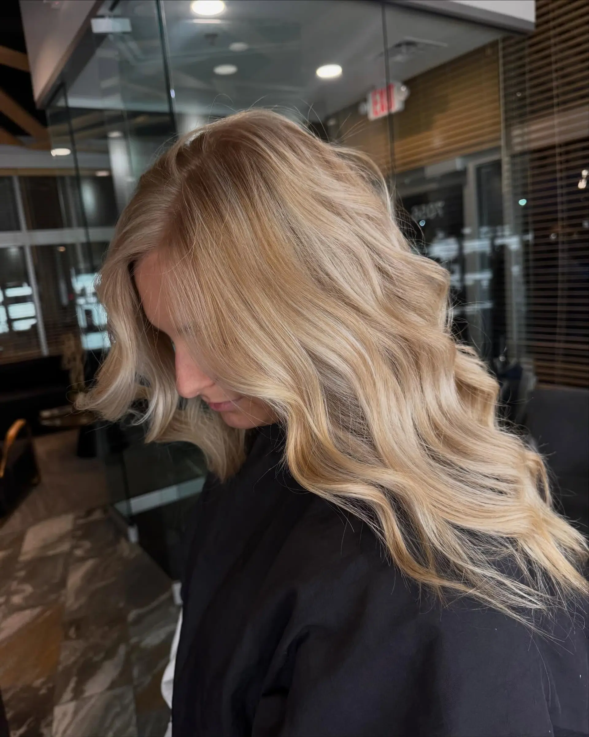 Long creamy blonde hair styled with soft, cascading waves and a smooth finish. 1