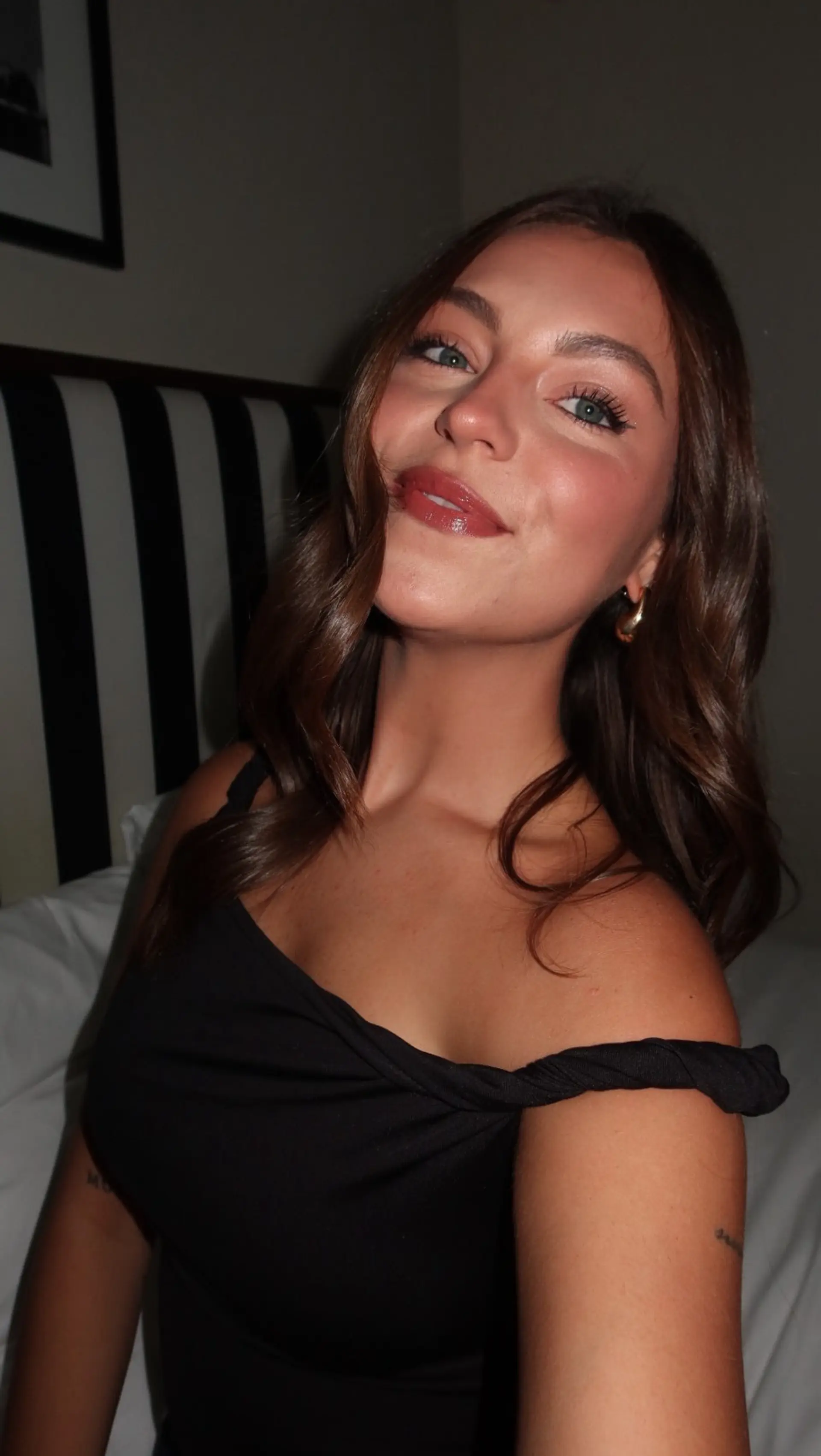 Glossy, rich brunette hair styled in soft, bouncy waves with a center part framing the face. 1
