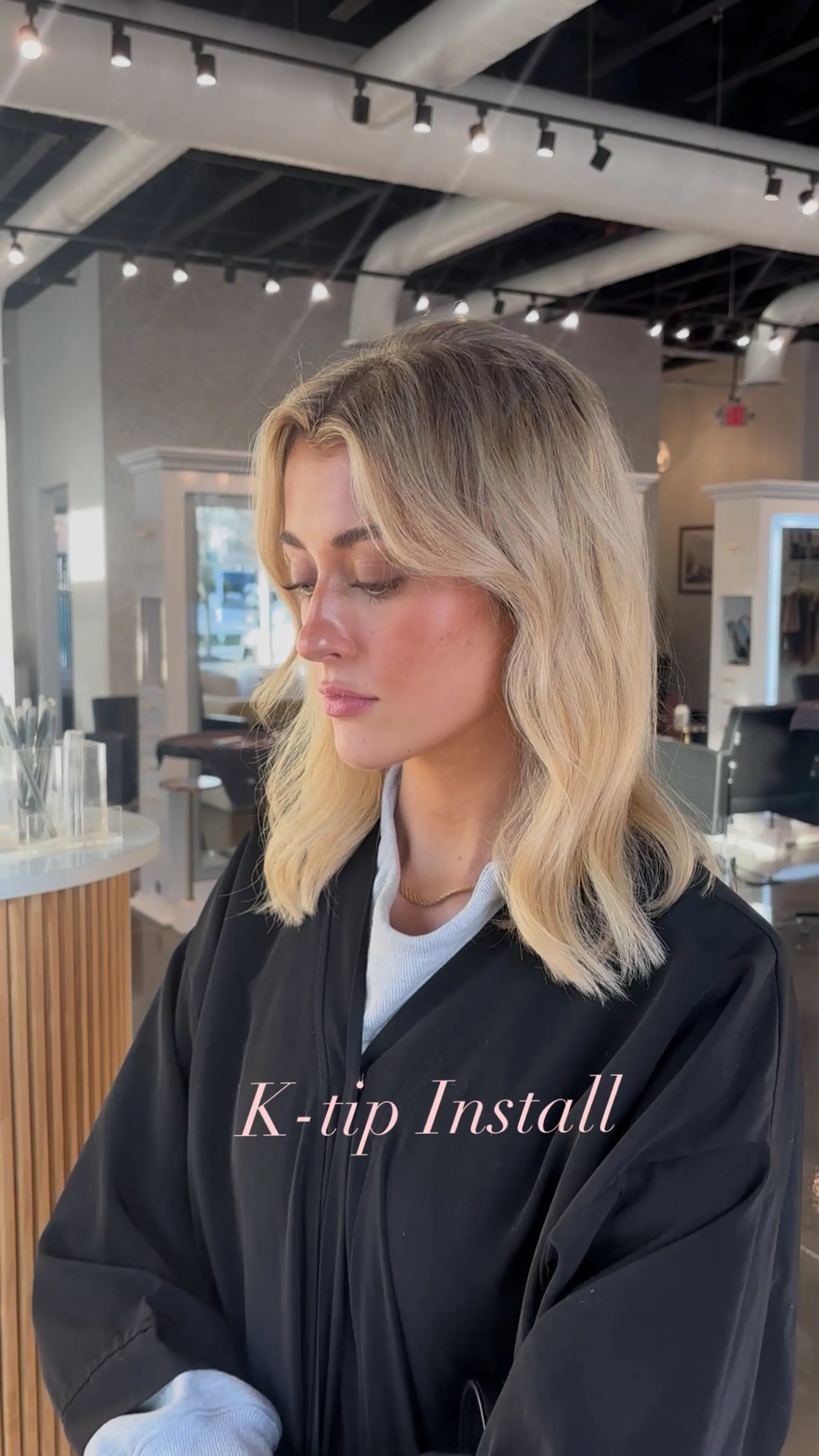 Collarbone-length warm dimensional blonde hair styled with soft natural waves, center parting, and face-framing curtain layers. 1