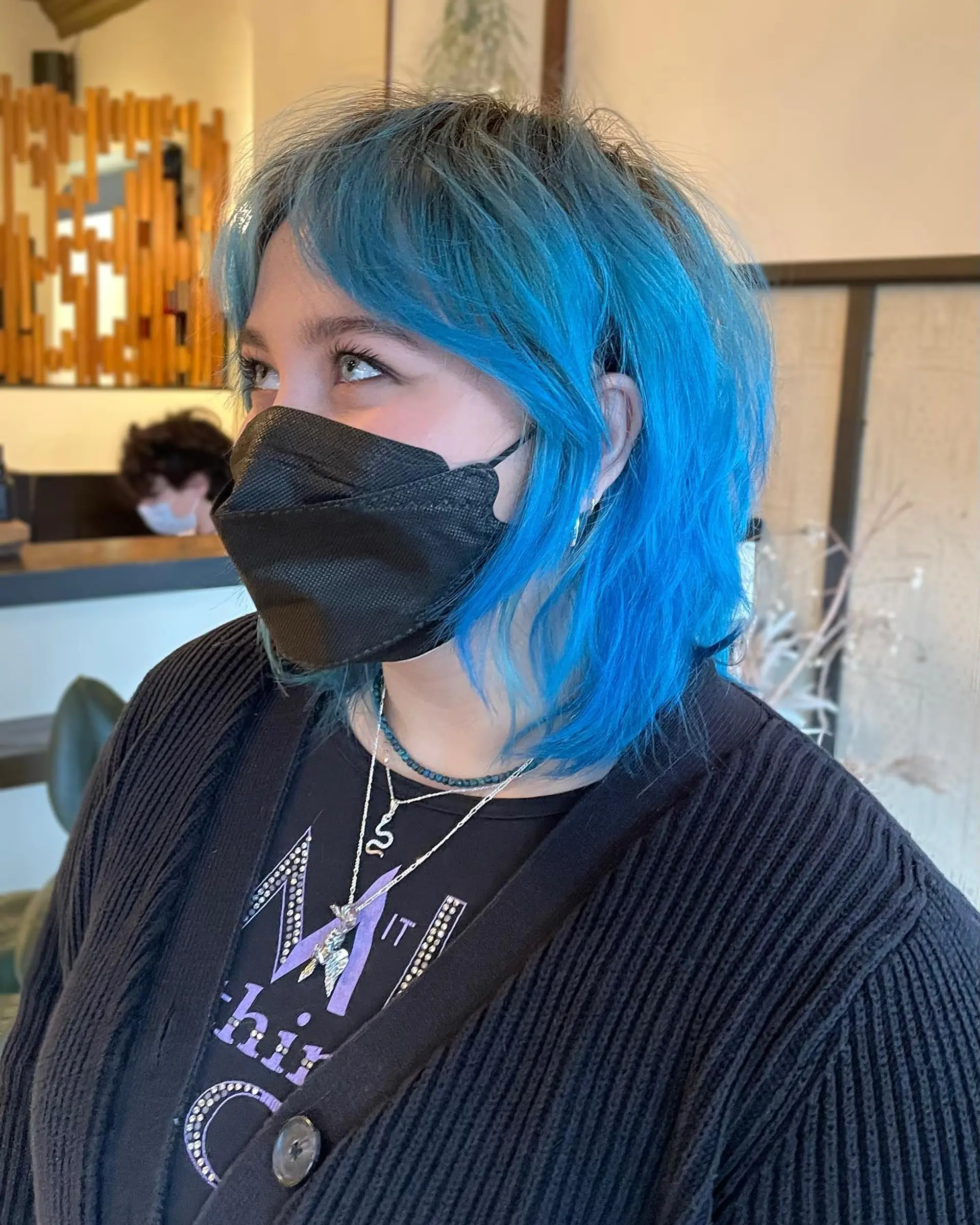 A modern shag haircut with choppy layers and vibrant blue color with a subtle root shadow. 1