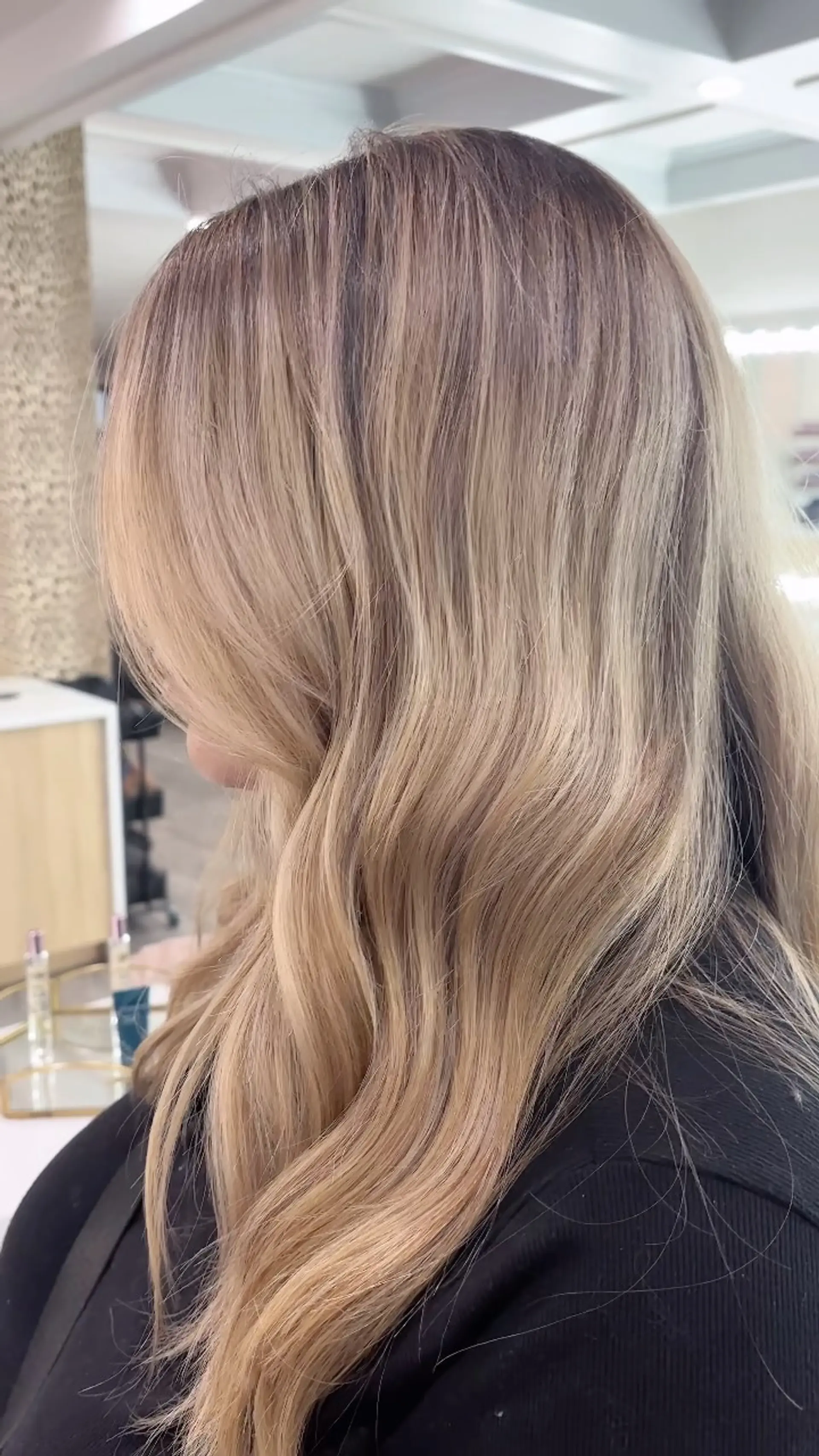Long warm blonde hair styled in loose waves with a seamless shadow root transition. 1