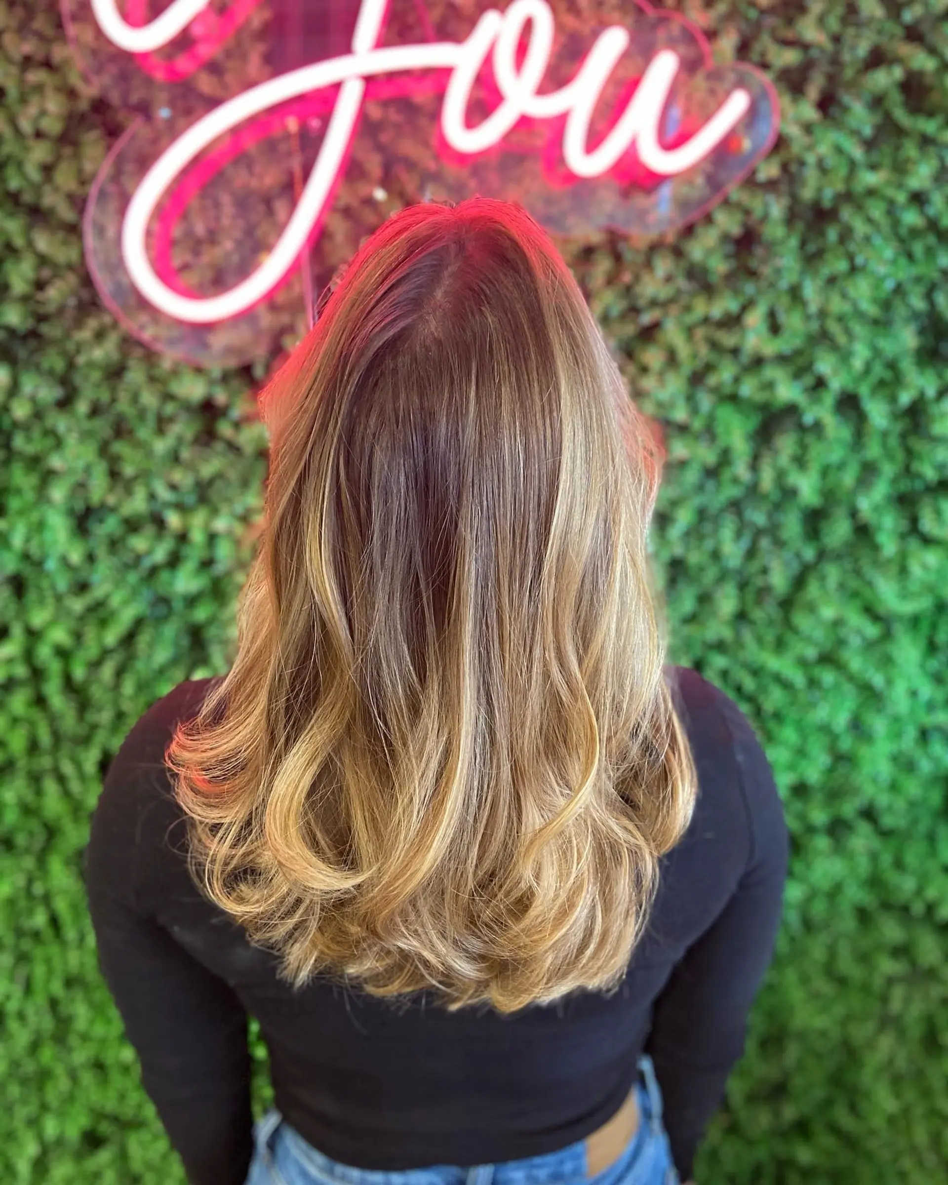 A soft, lived-in blonde balayage seamlessly blended over a natural brown base, finished with smooth length and soft curls at the ends. 1
