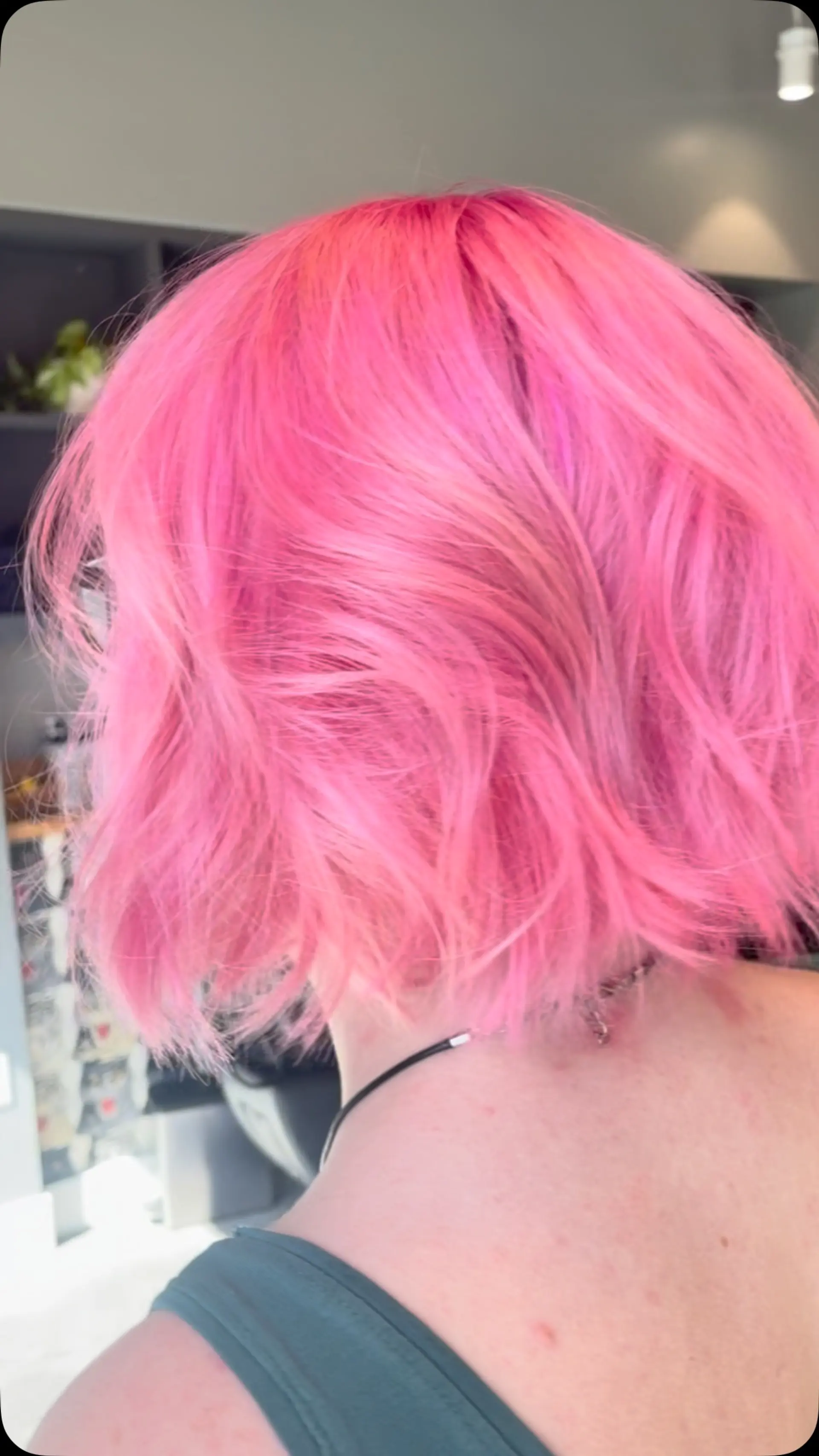 A textured short crop bob in a vibrant bubblegum pink shade with tousled waves. 1