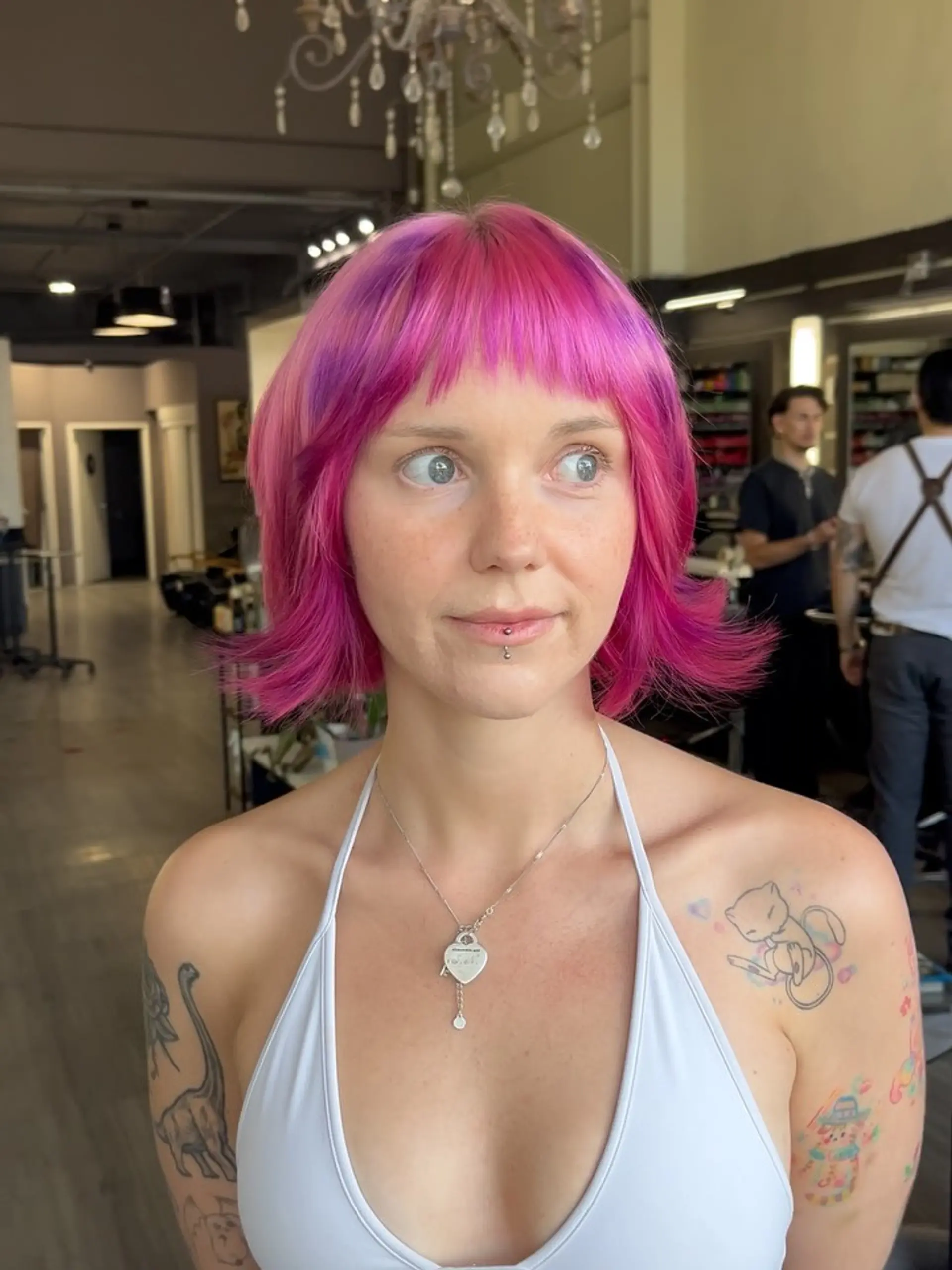 A vibrant short layered bob styled with playful flipped-out ends and textured, piecey micro bangs framing the face. 1