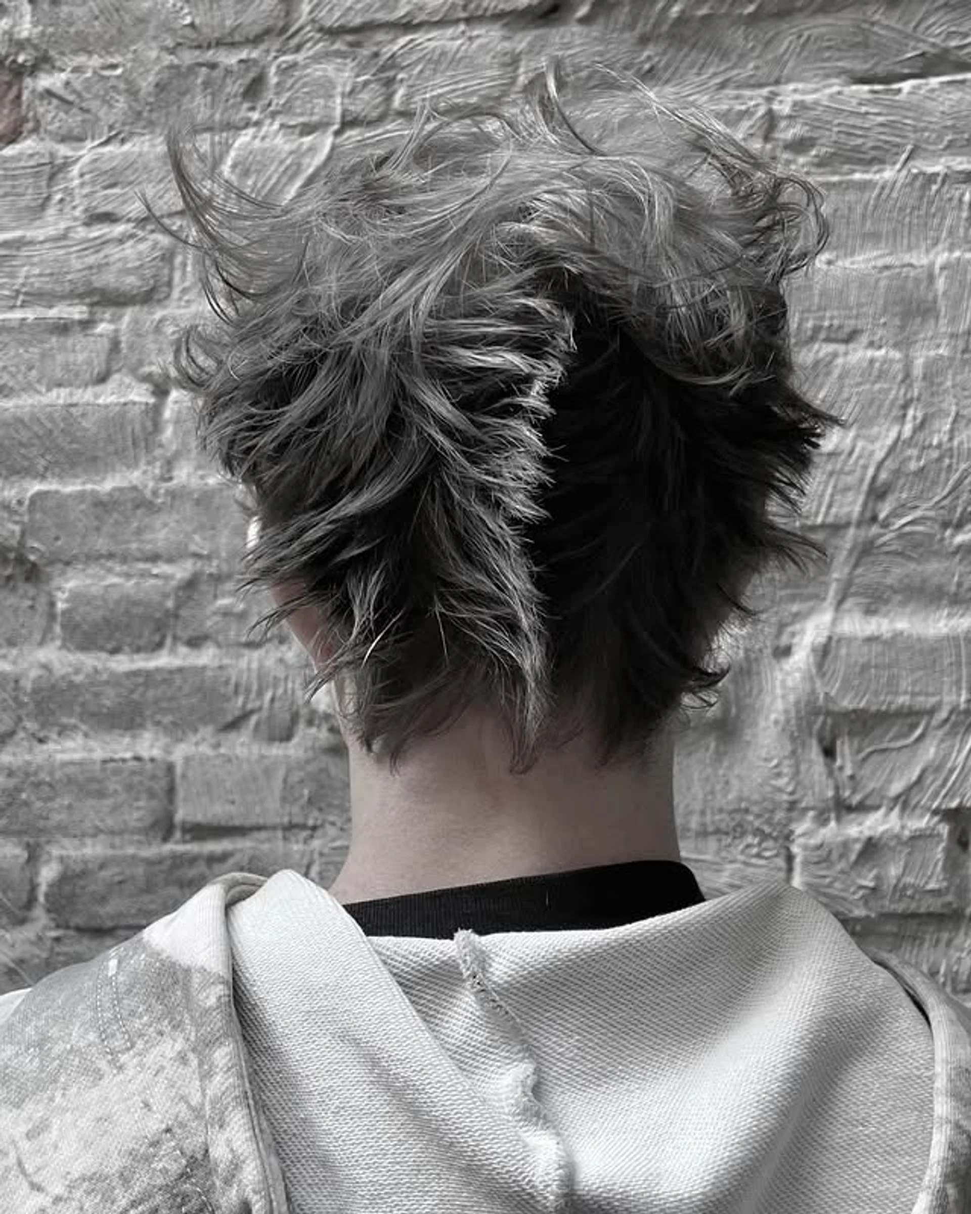 A short, curly pixie cut featuring textured layers and natural silver highlights - Preview 1