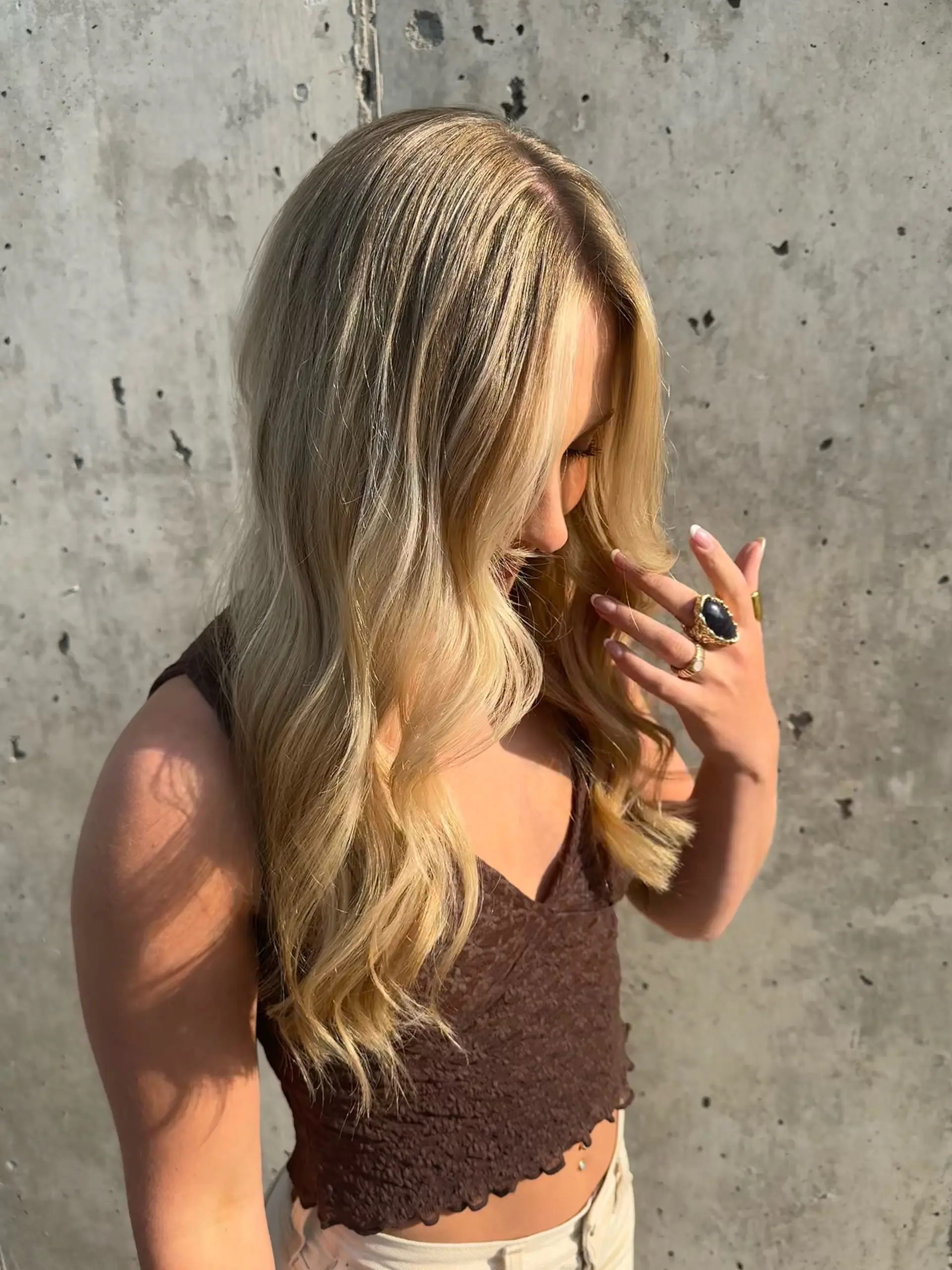 Long dimensional blonde hair featuring luminous woven ribbons of highlight and styled in soft loose waves. 1