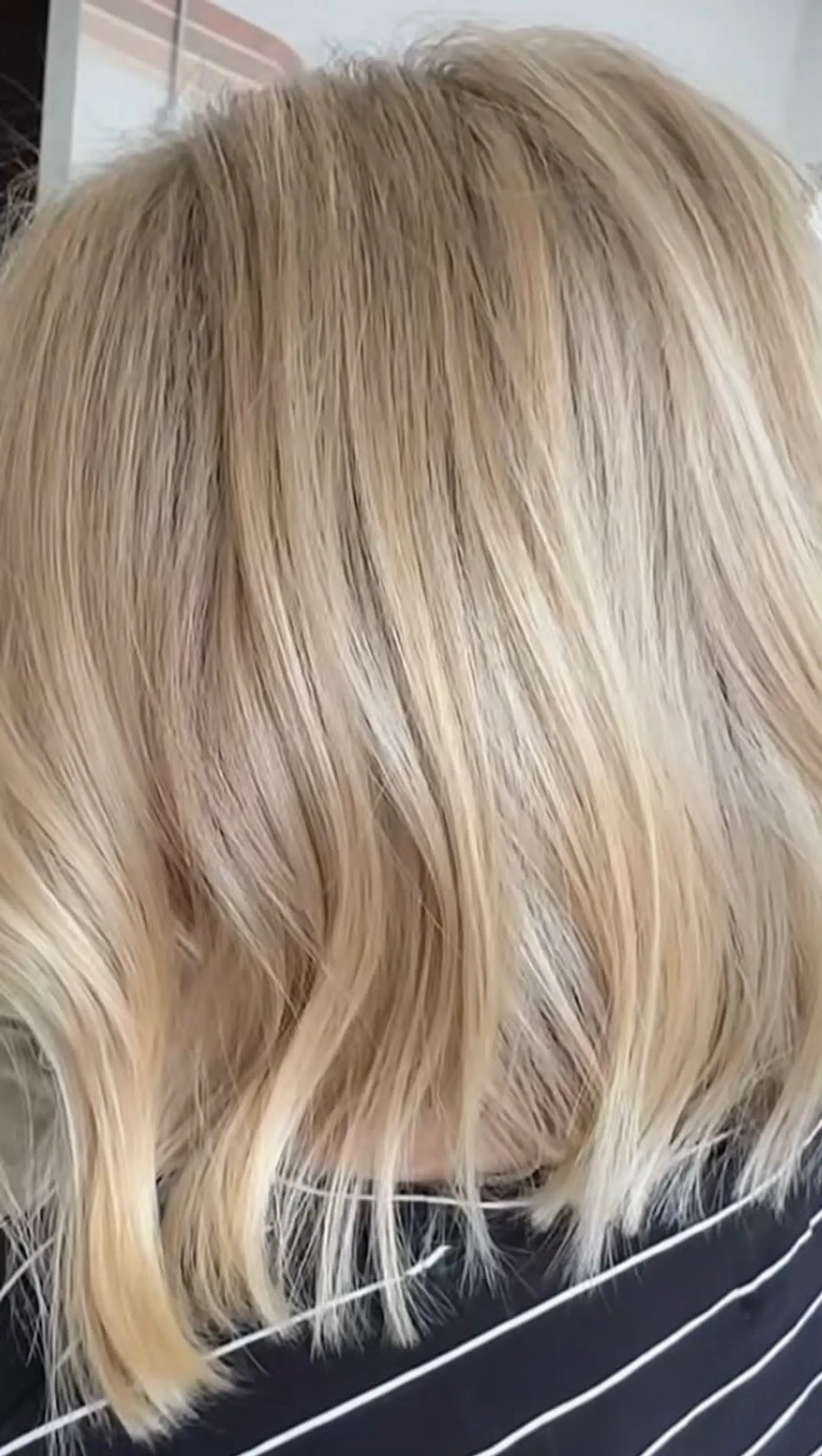 A blunt, textured milky blonde bob with soft movement resting just above the shoulders. 1