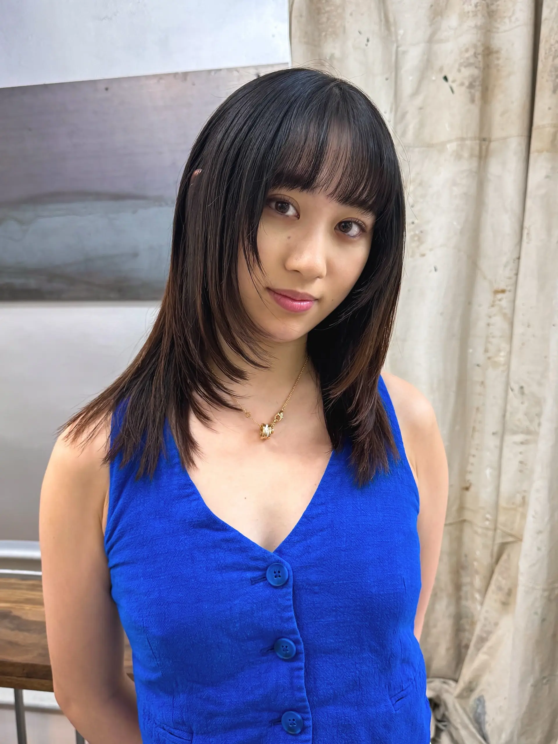 A trendy medium-length wolf cut with wispy baby bangs and face-framing layers. 1