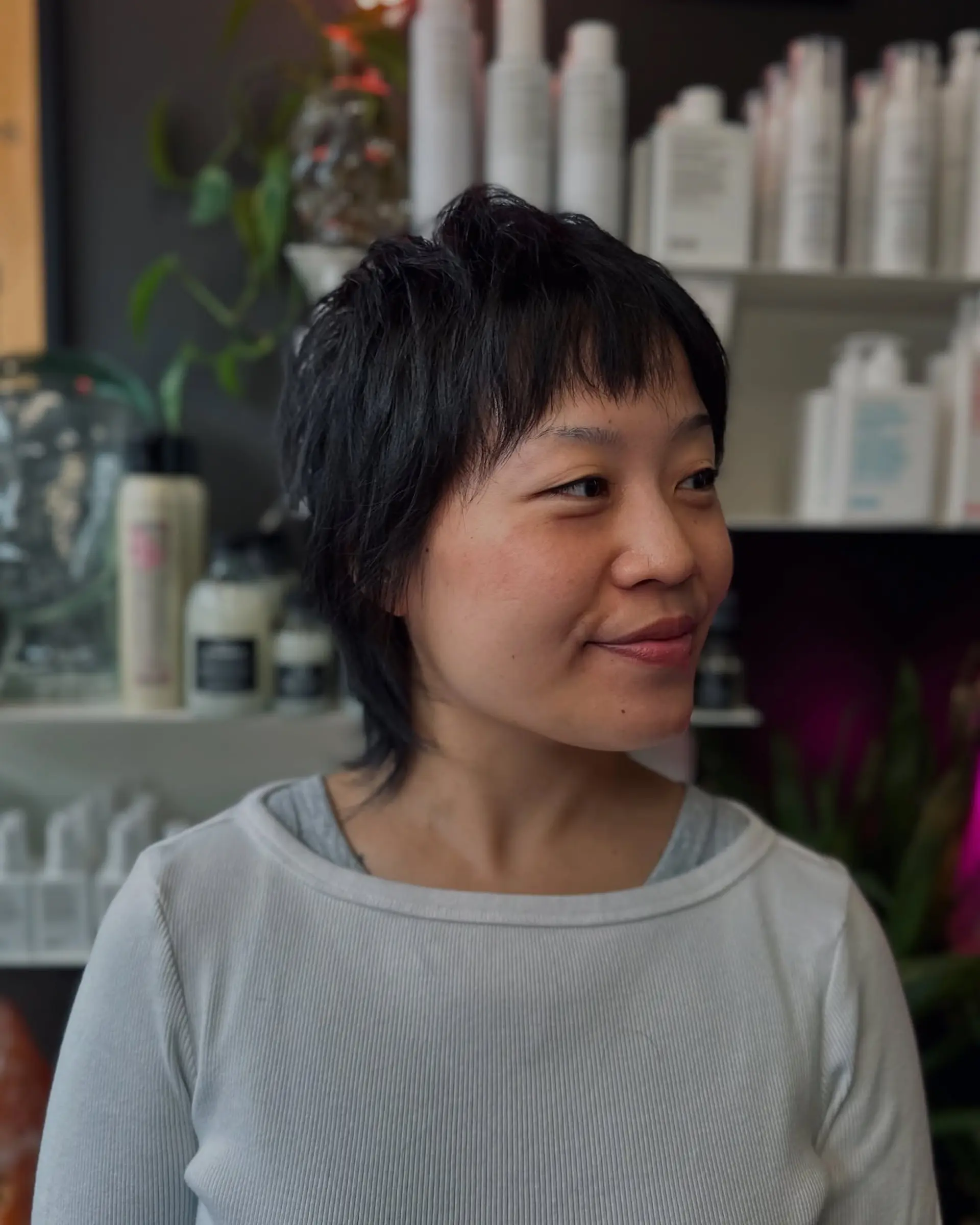 A textured short pixie shag featuring piecey micro bangs and tapered nape length. 1
