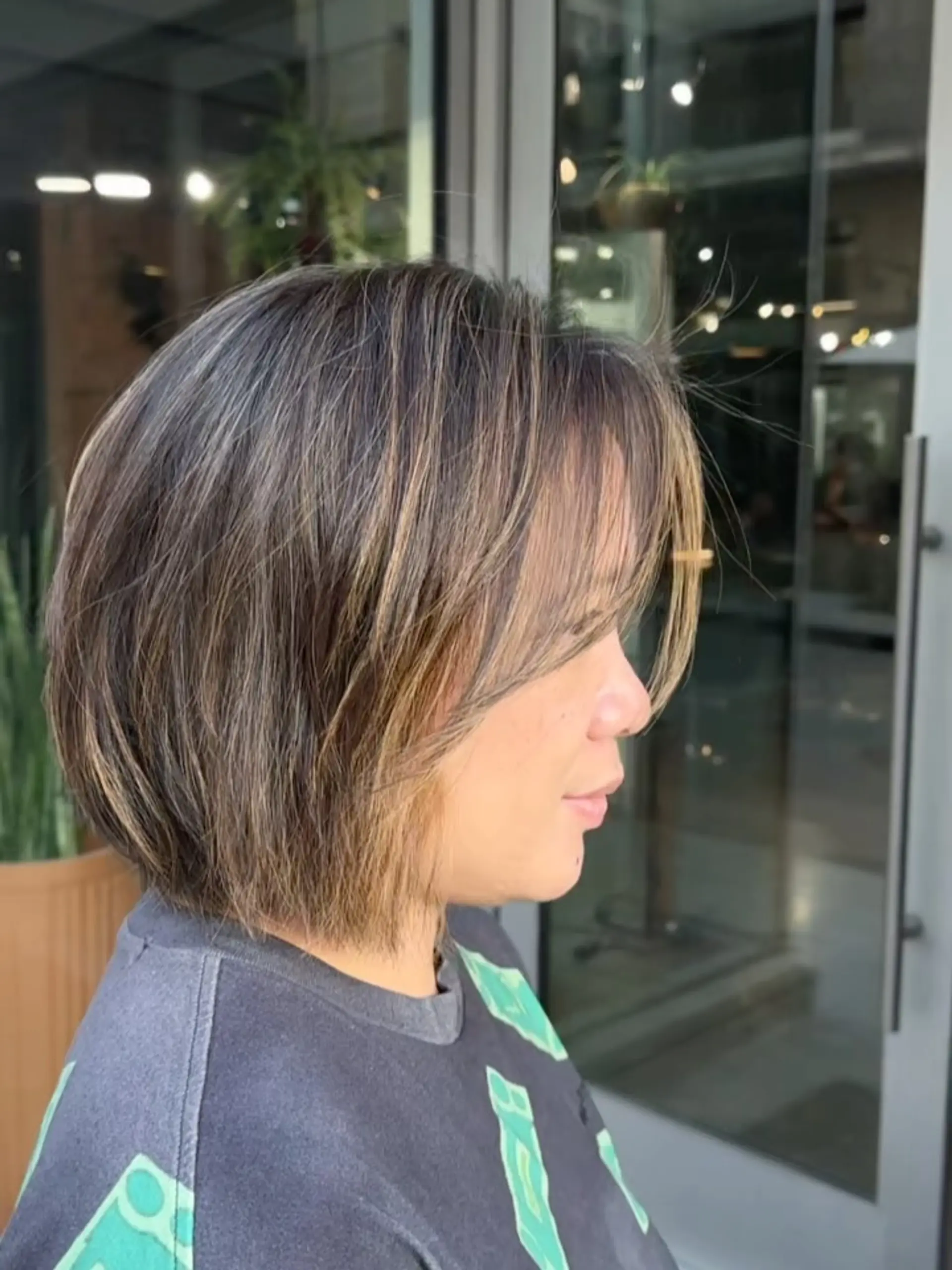 A textured chin-length bob with soft, wispy face-framing fringe and subtle dimensional highlights. 1