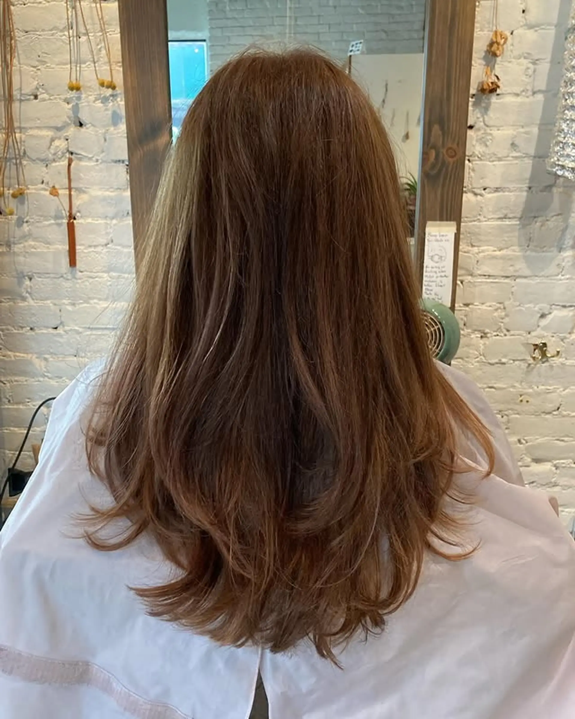 Long, layered wavy hairstyle with a bronzed balayage. 1