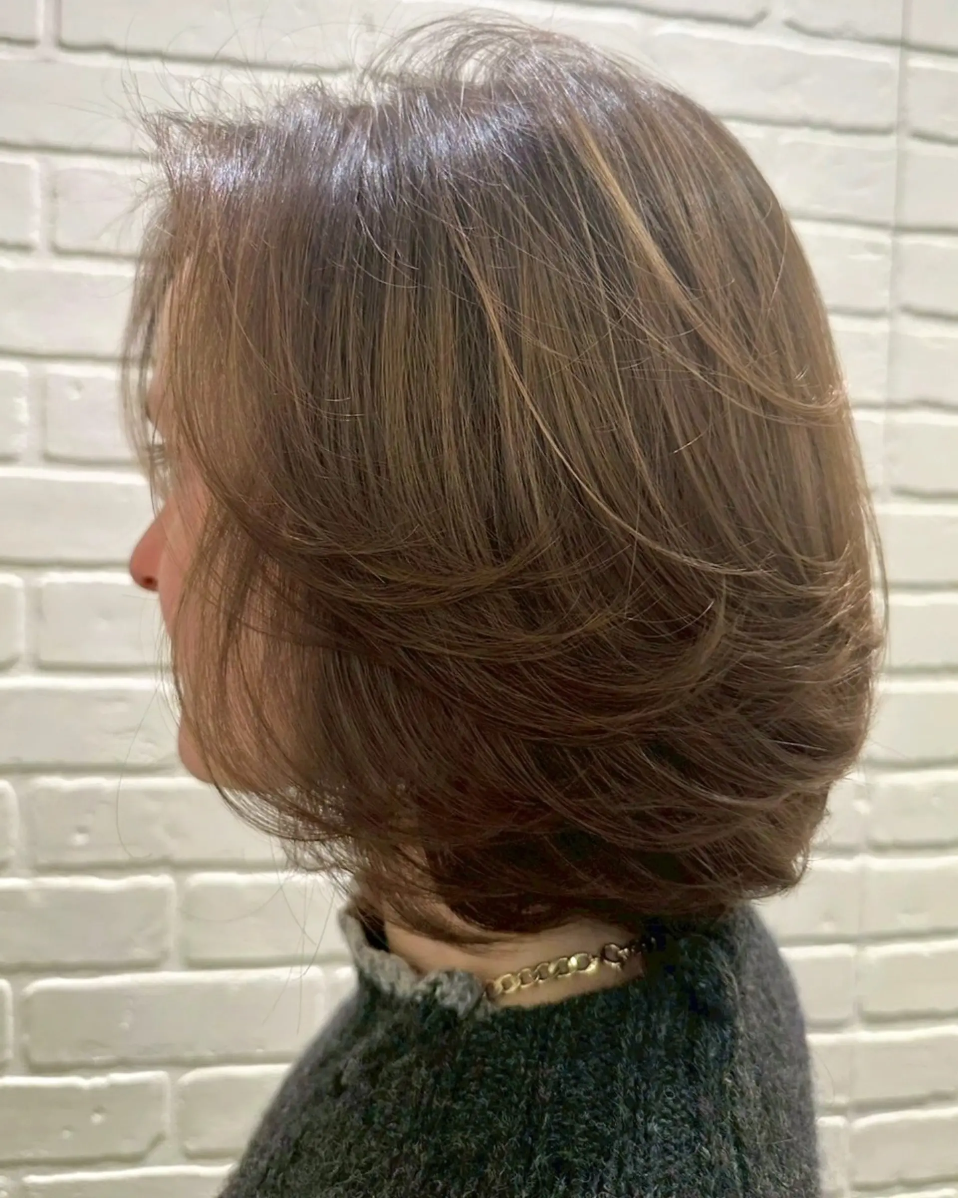 A voluminous layered bob featuring soft, feathered ends styled in a rounded blowout. 1