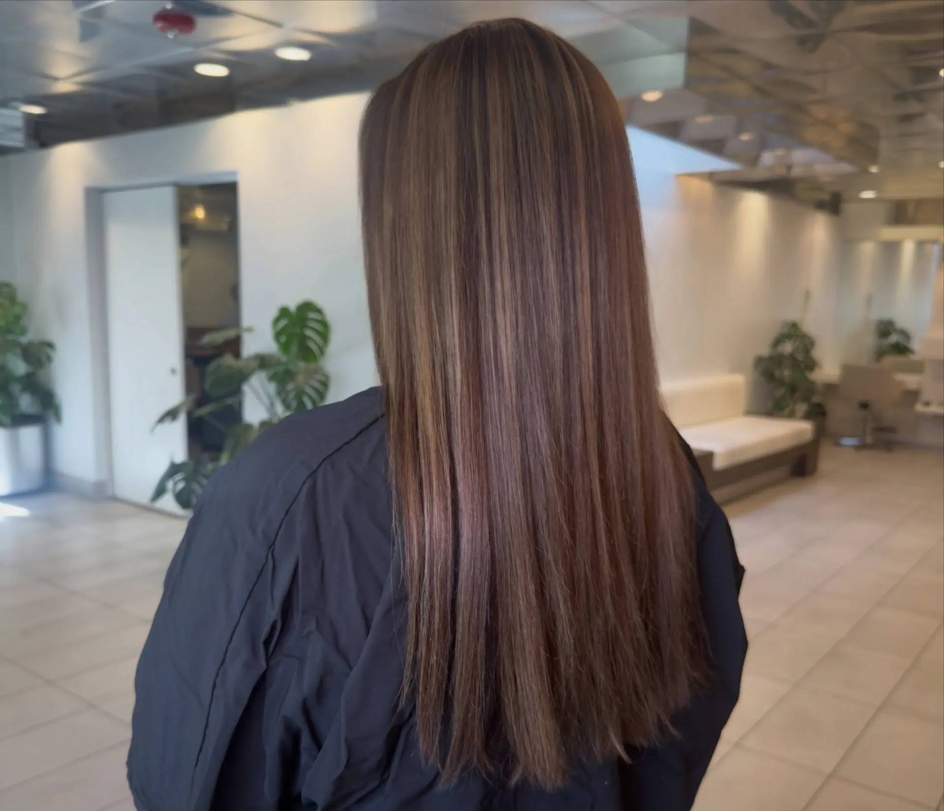 Long, glossy straight brunette hair with finely blended warm caramel and chestnut highlights. 1