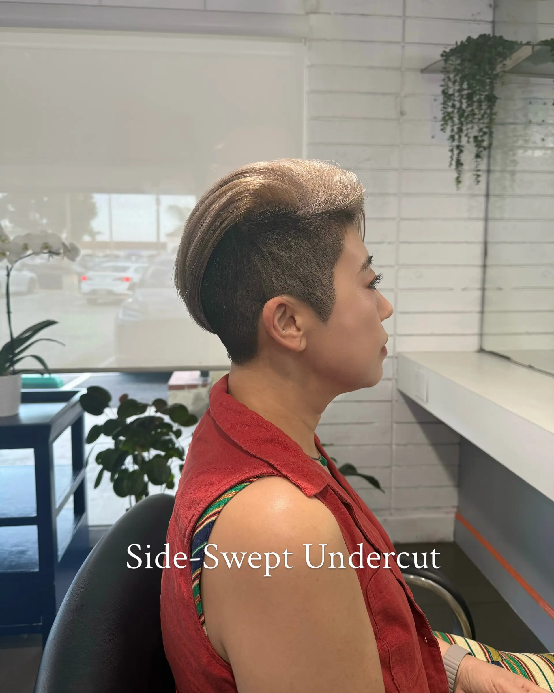 A modern side-swept undercut with closely tapered sides and a longer, voluminous top brushed smoothly to the side. 1