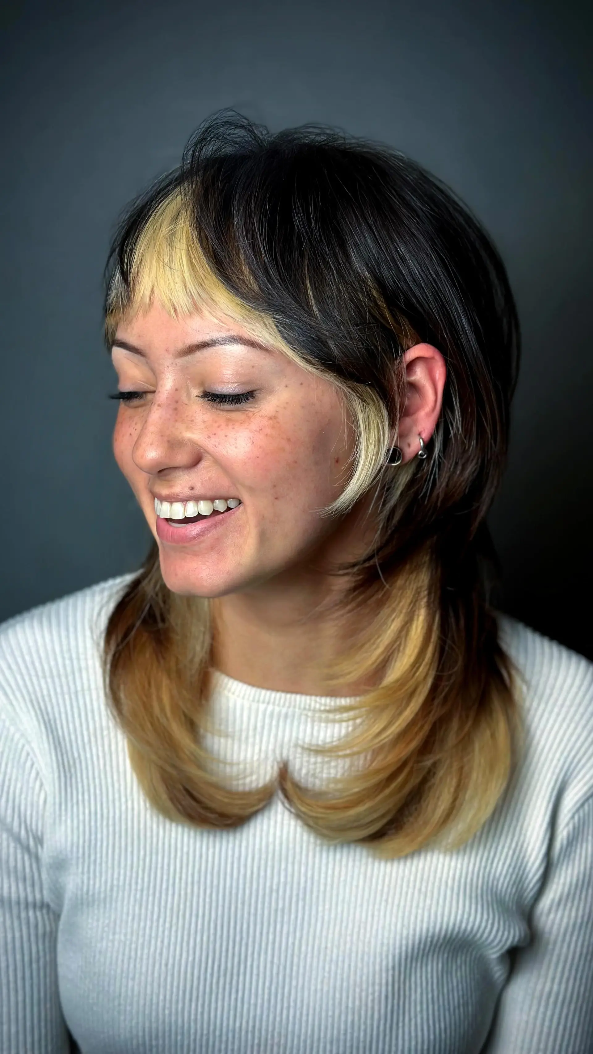 A razor-cut modern shag mullet with textured micro bangs, face-framing fringe pieces, and blonde color-blocked panels. 1