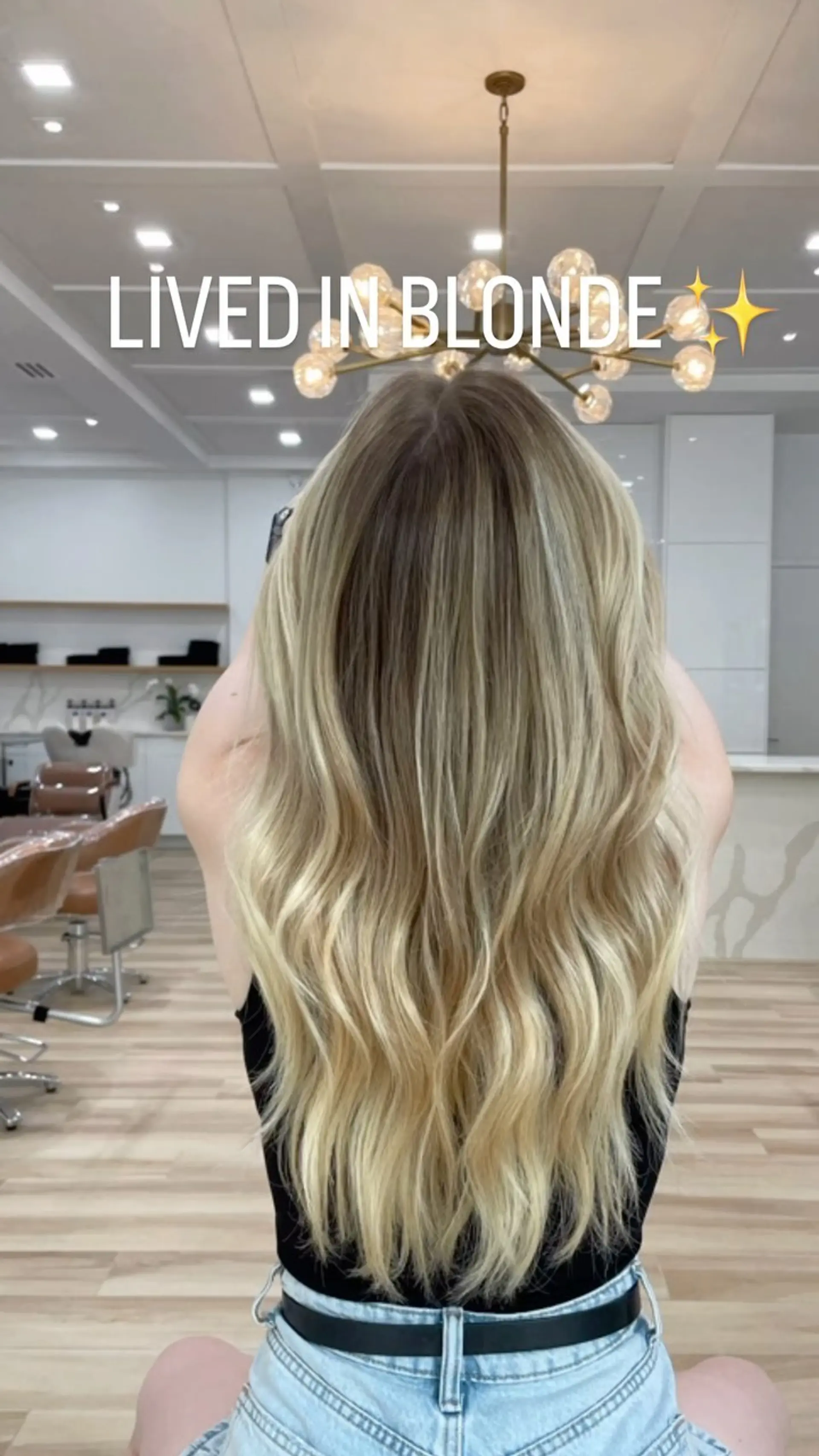 Long lived-in blonde hair featuring a natural shadowed root and soft waves through the lengths. 1
