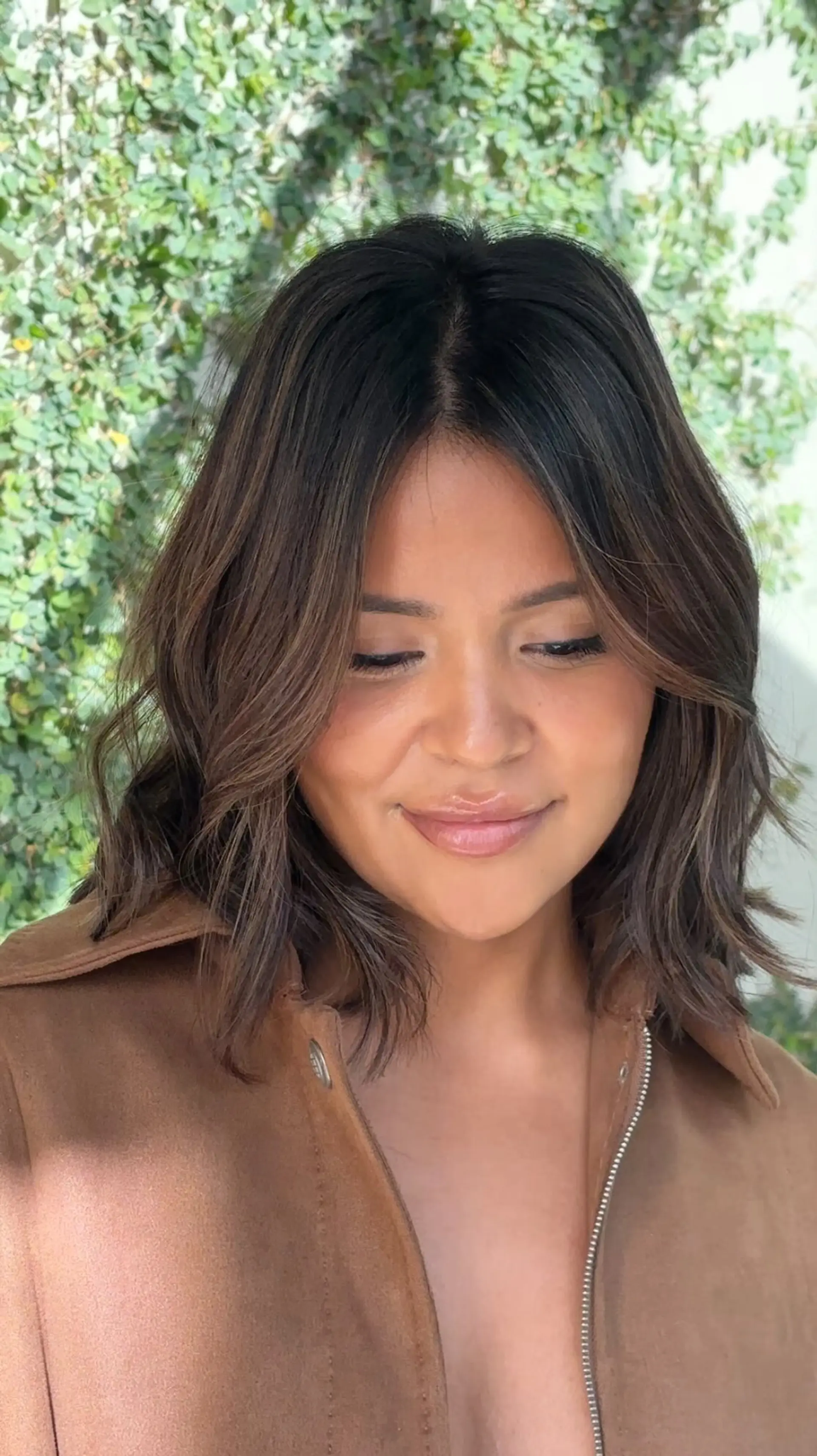 A shoulder-length textured long bob styled with soft, natural bends and center-parted face-framing layers. 1