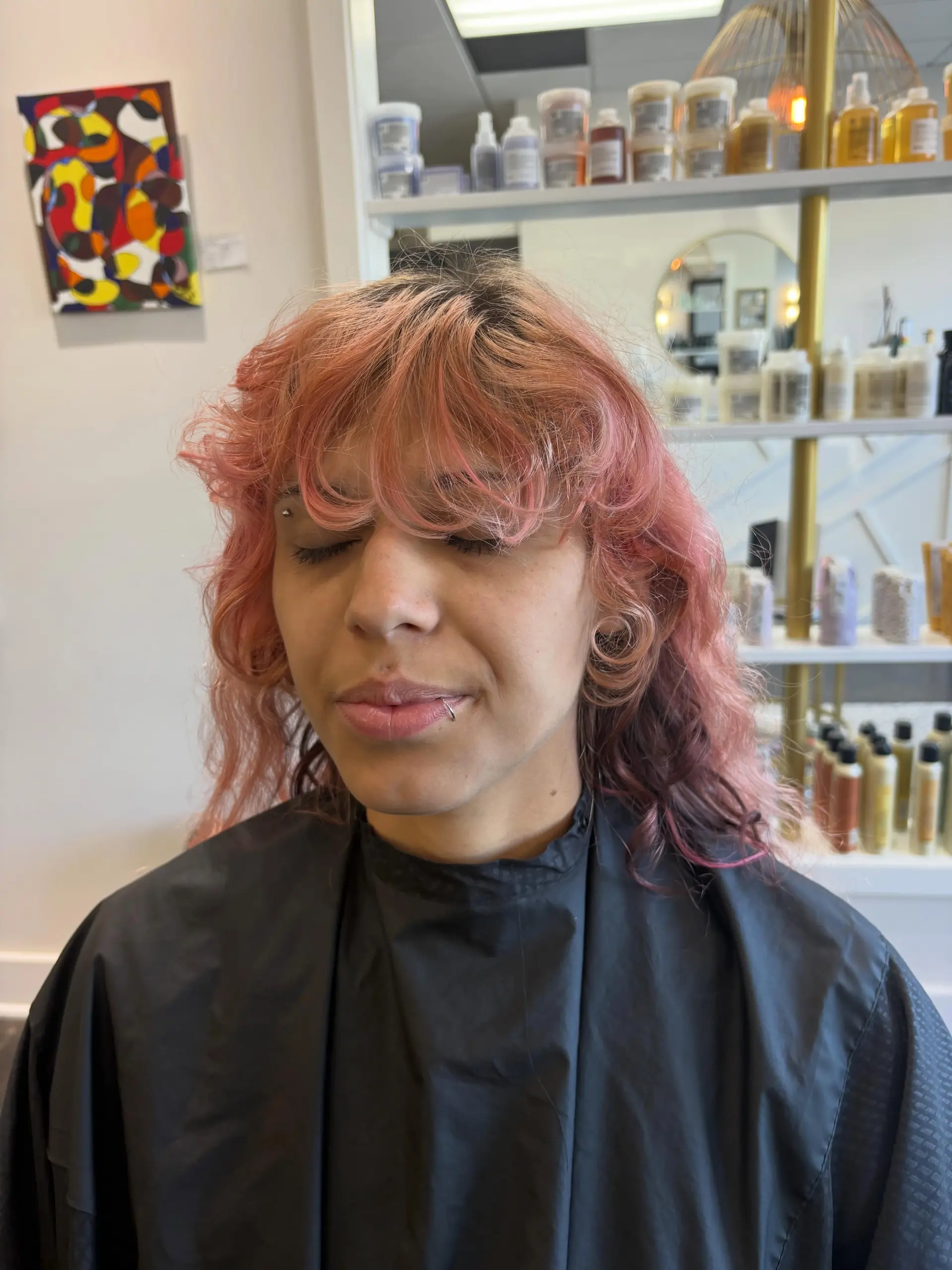 A medium-length textured mullet cut with soft wavy layers and full, wispy fringe in pastel pink. 1