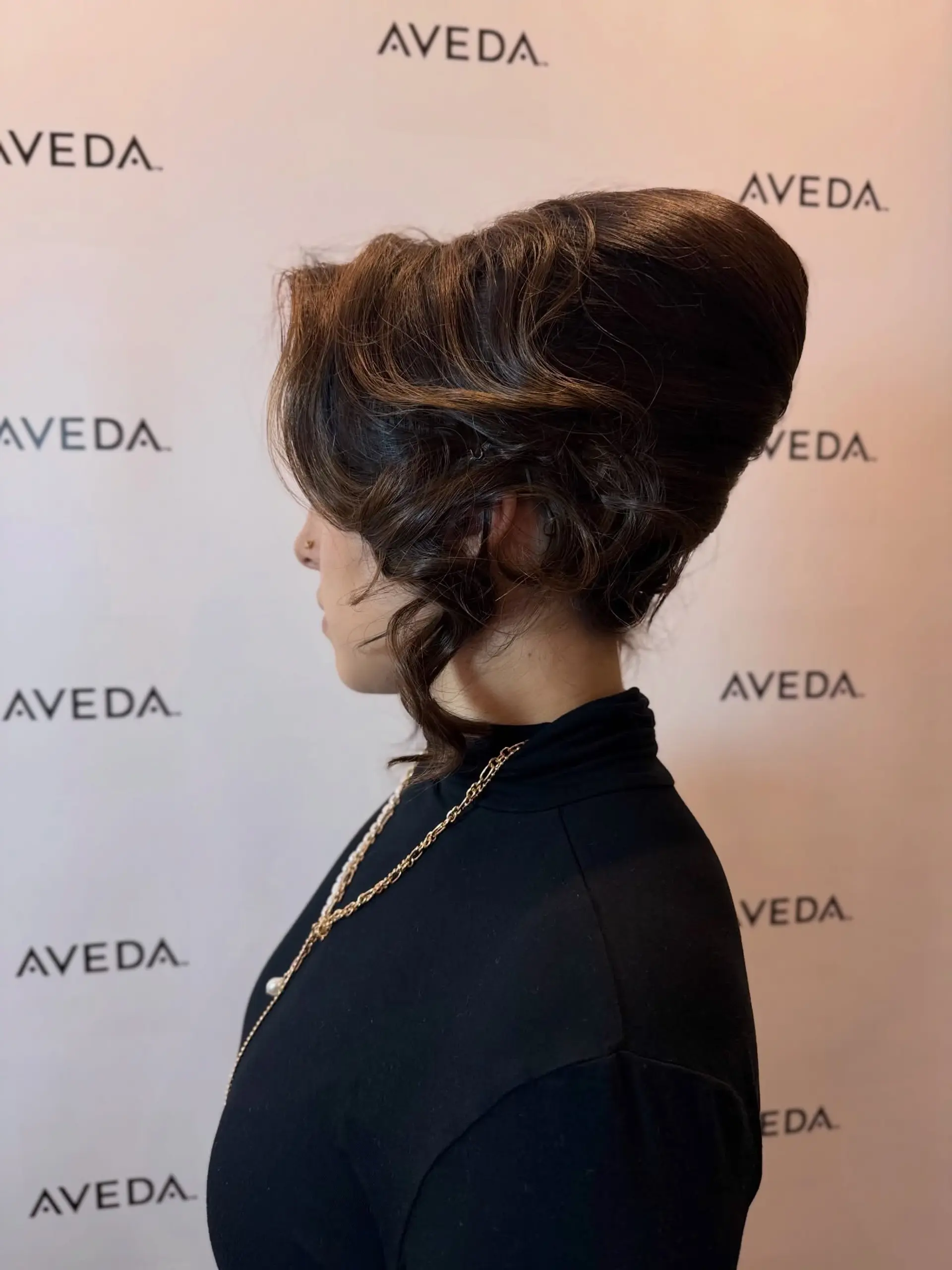 A glamorous 1960s-inspired bouffant updo with sculpted volume at the crown and soft, face-framing curls. 1