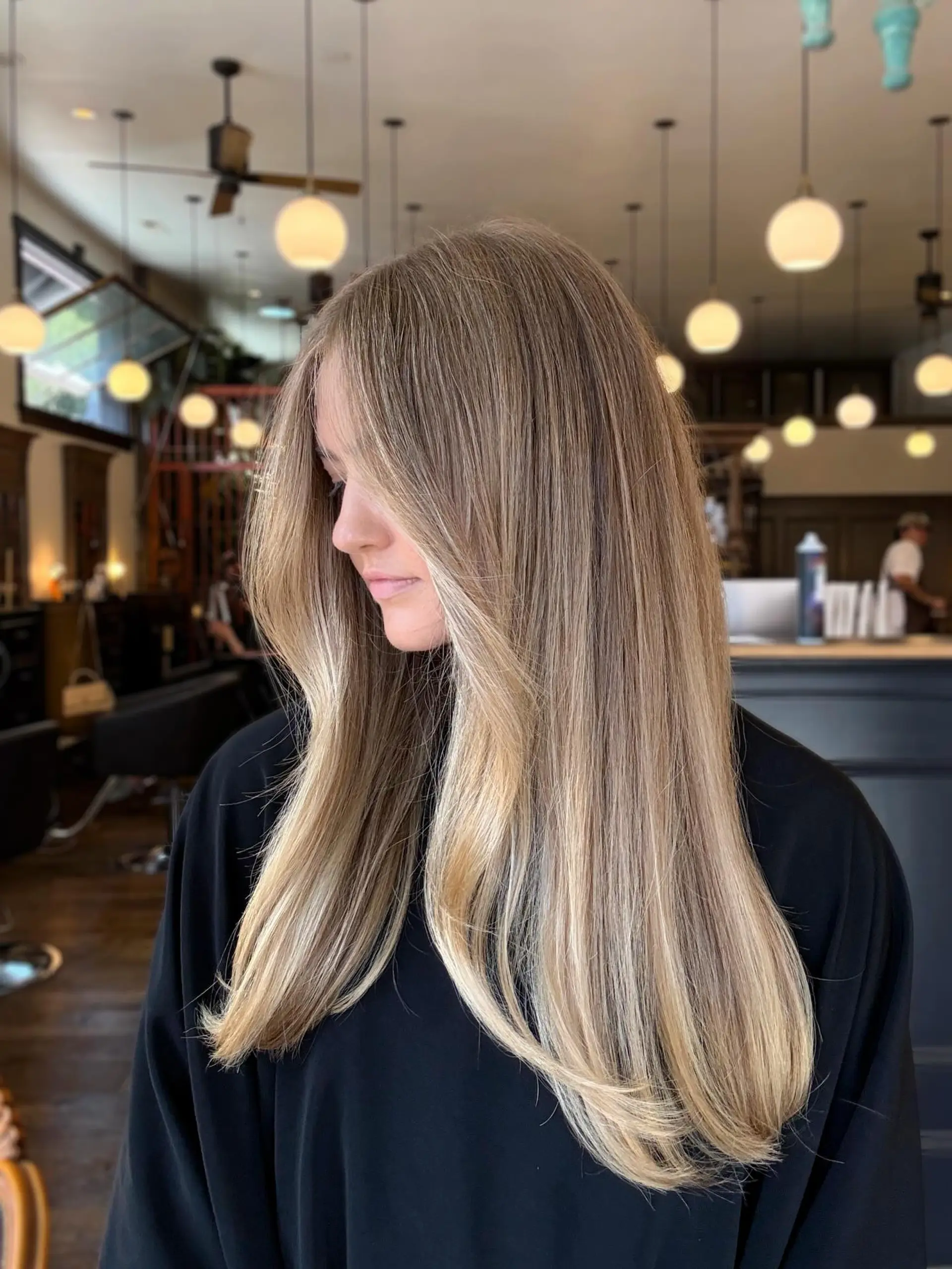 Long, sleek blonde hair with seamless, dimensional lived-in highlights and soft face-framing layers. 1