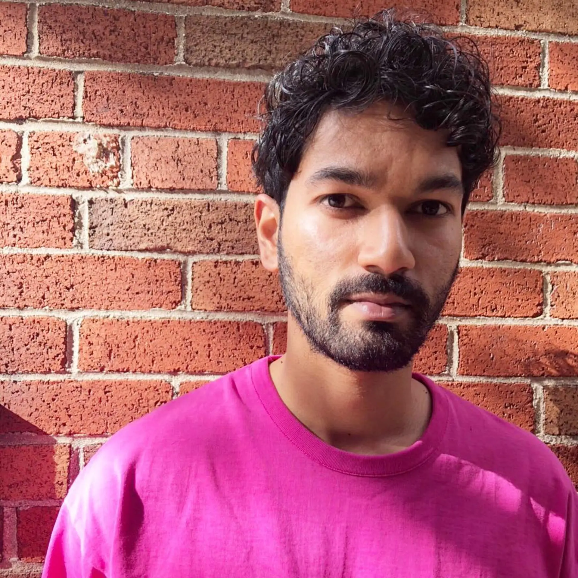 Short, curly hair with a textured, voluminous appearance, providing a sense of controlled chaos that enhances the overall style. 1