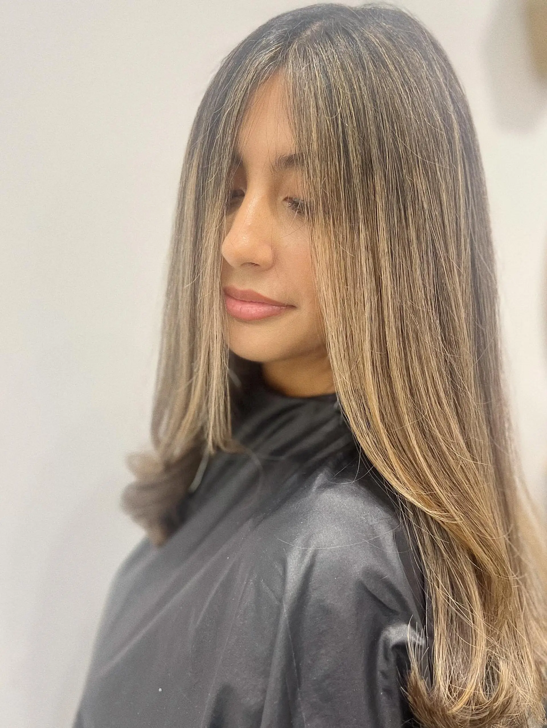 Long smooth brunette hair detailed with seamless, fine ash blonde highlights and softly beveled ends. 1