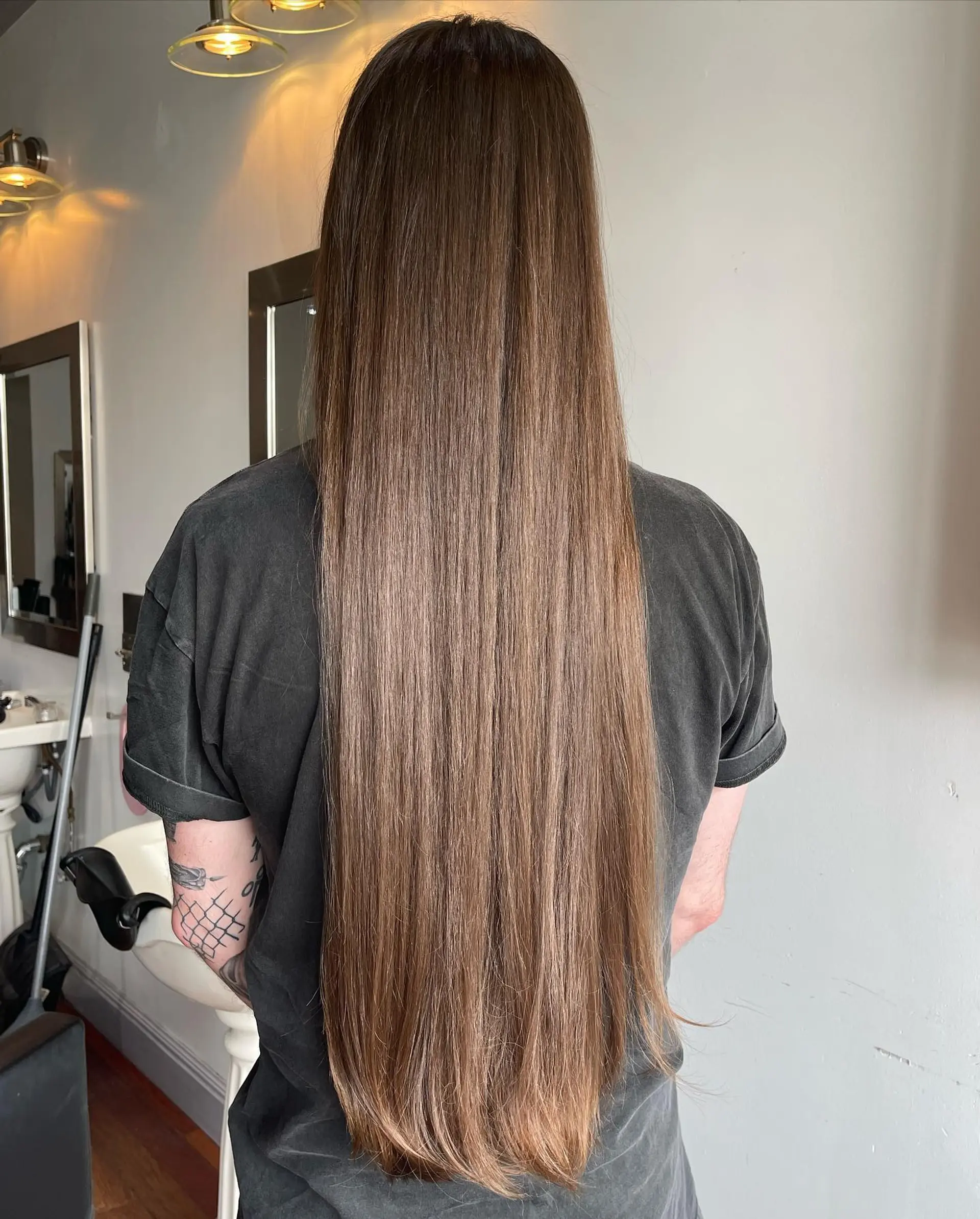 Ultra-long, smooth brunette hair falling past the waist in a sleek, straight blowout style. 1