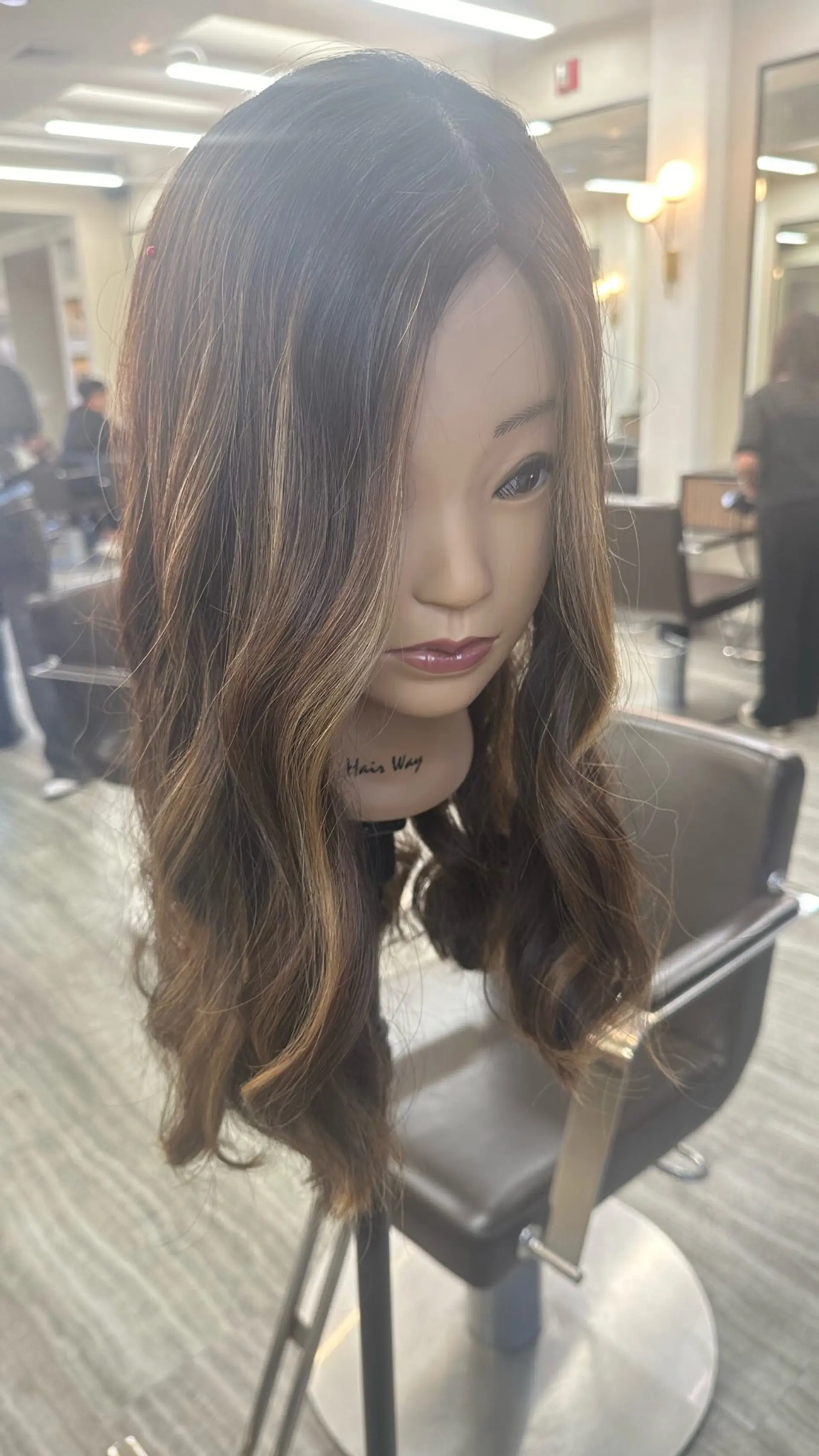 Long brunette hair styled in loose, flowing waves with warm caramel highlights. 1