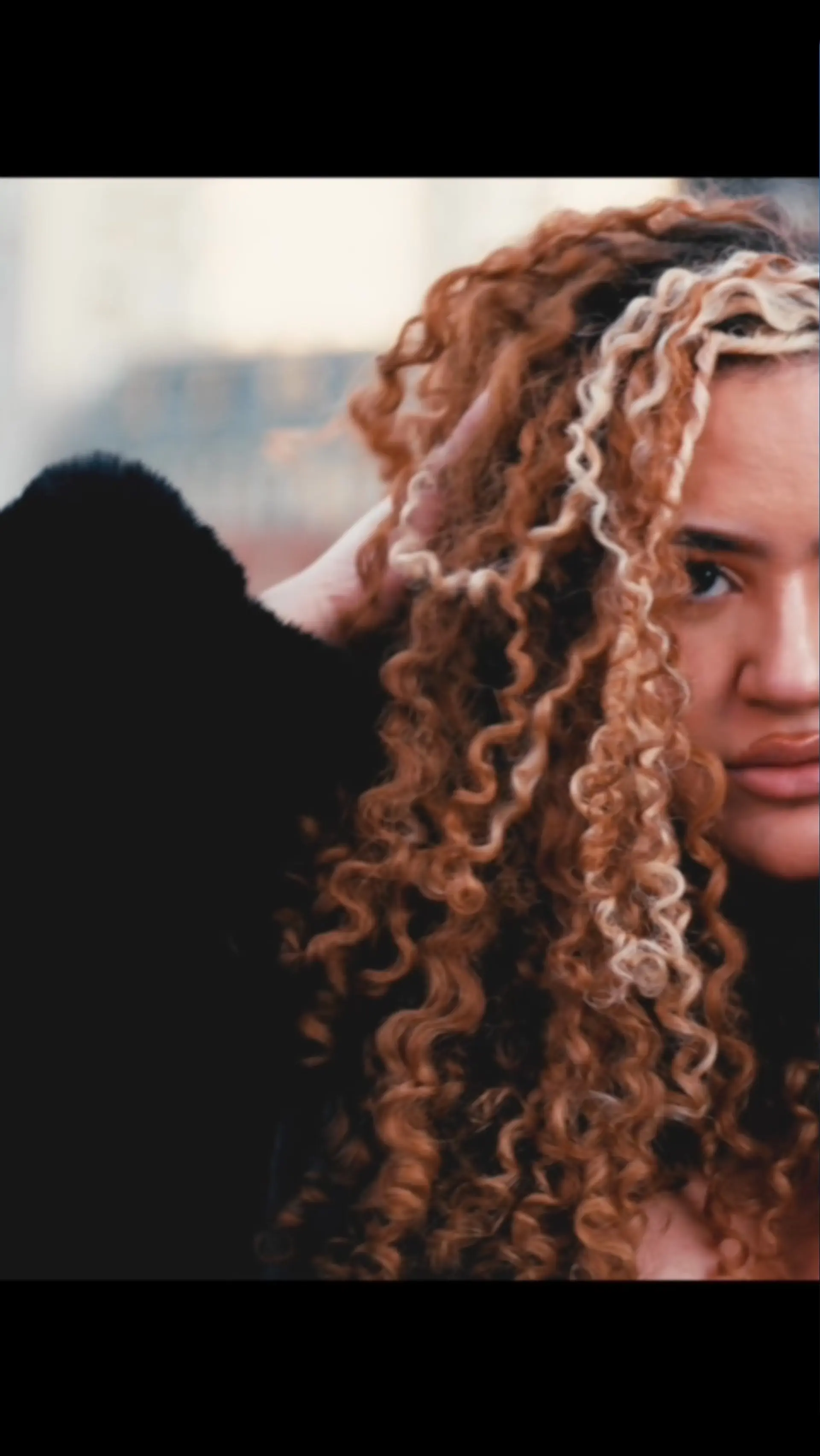 Defined spiral curls in a rich warm copper shade accented with a bright blonde face-framing money piece. 1
