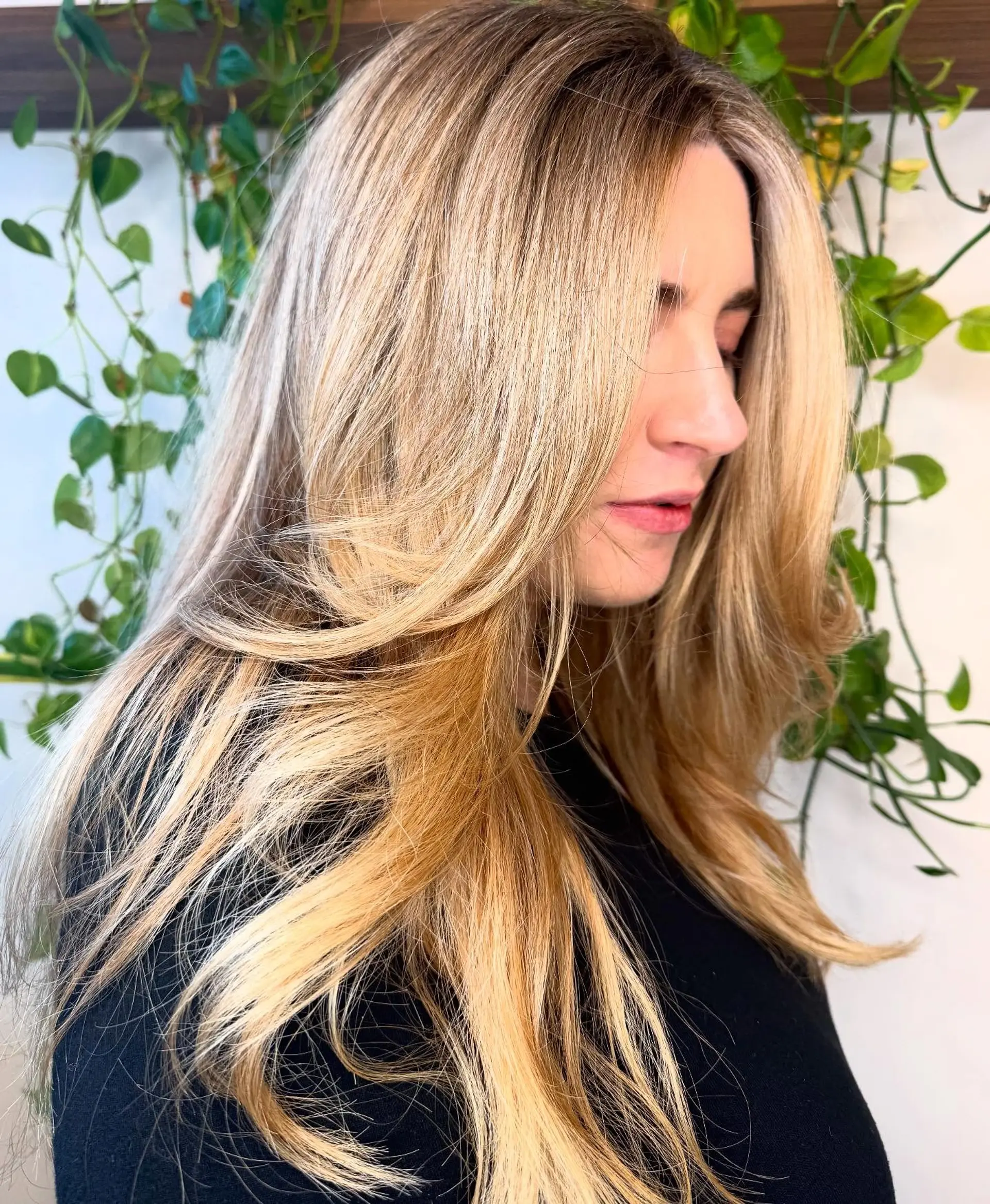 Long warm blonde hair styled with sweeping face-framing layers and soft blowout ends. 1