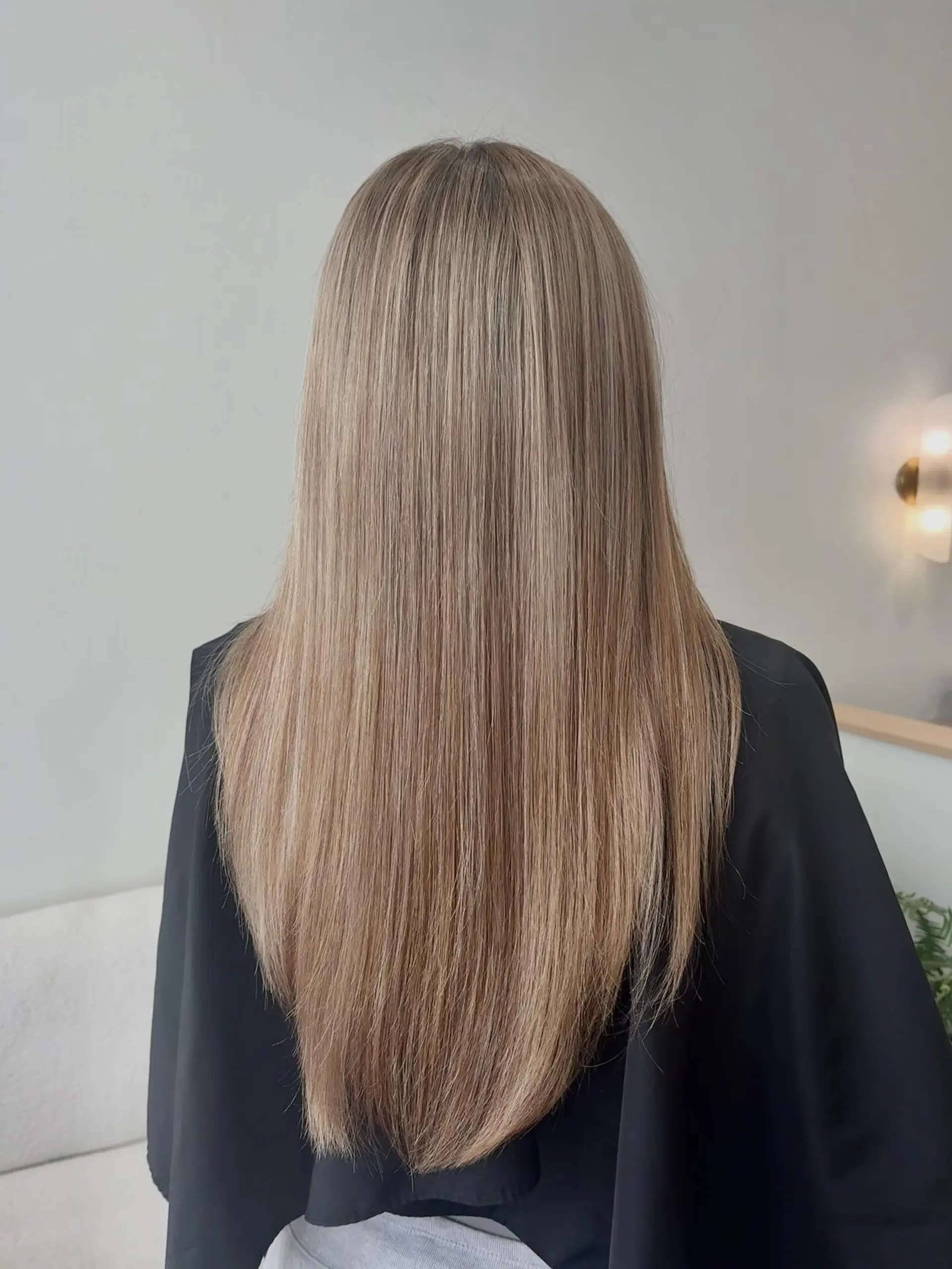 Long, pin-straight blonde hair styled smooth with a soft V-shaped cut. 1