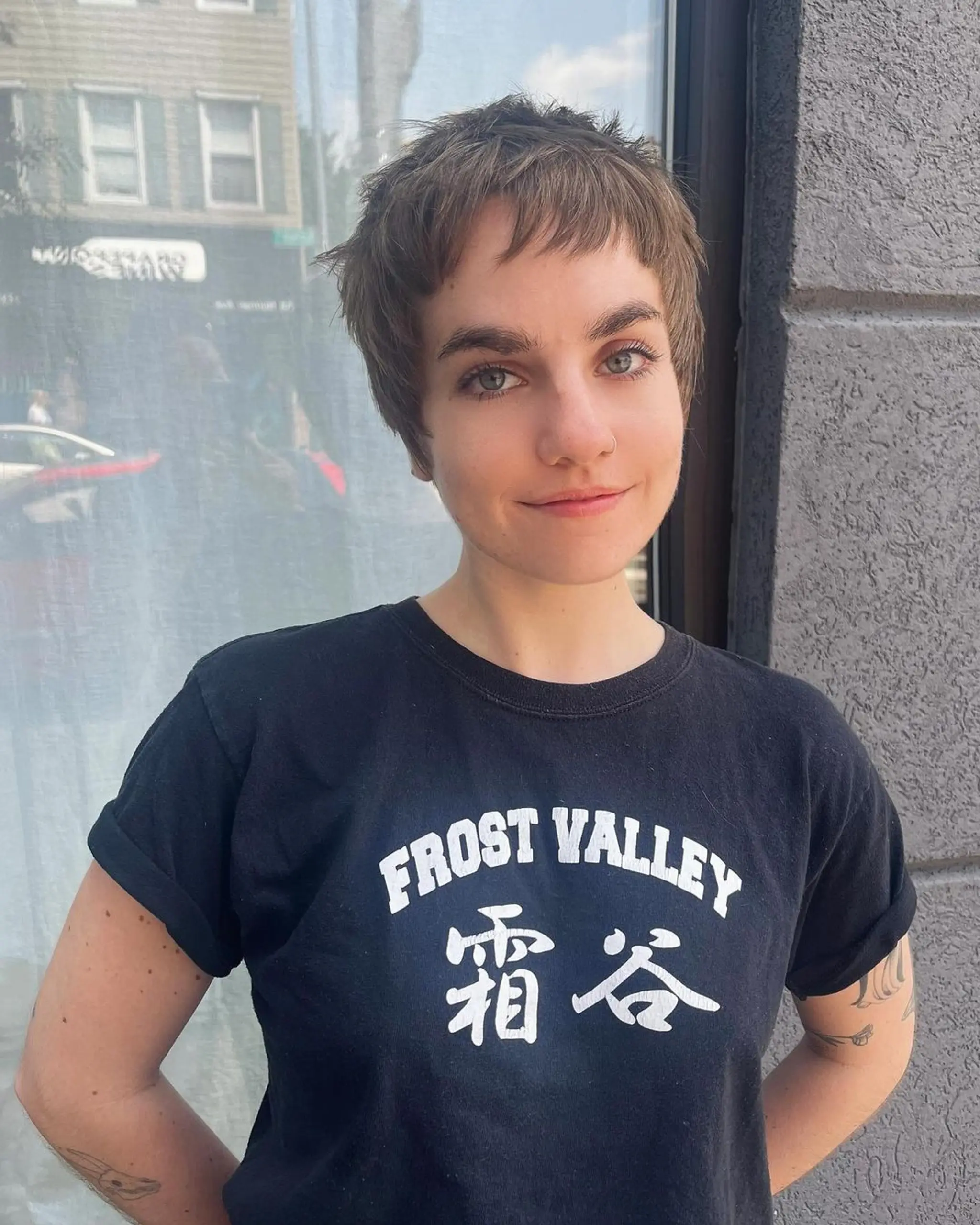 A very short, straight pixie cut featuring choppy layers and textured bangs, creating an undone, edgy style with a soft fringe.