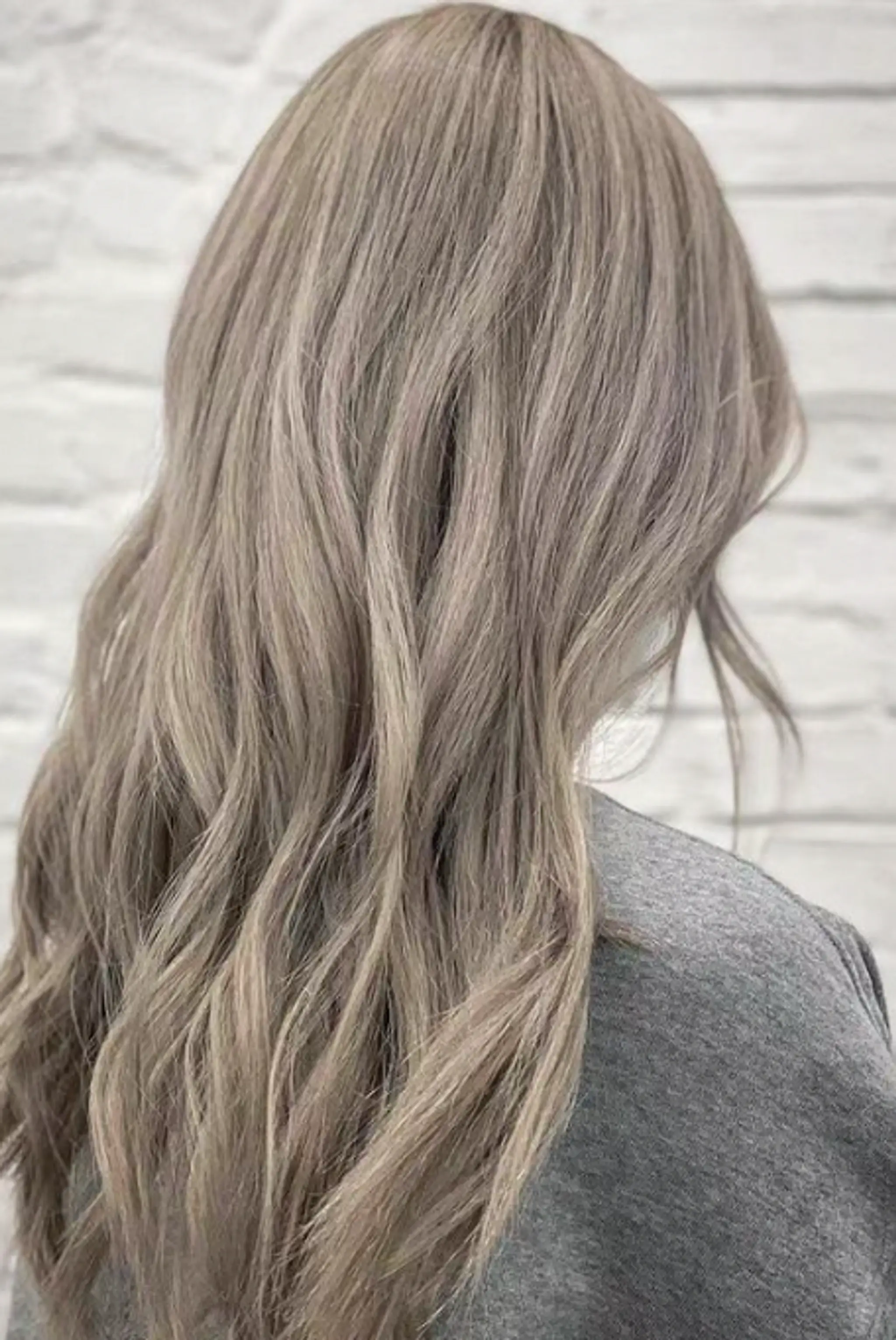 Long, wavy silver and platinum hair with natural, soft waves and subtle layers.