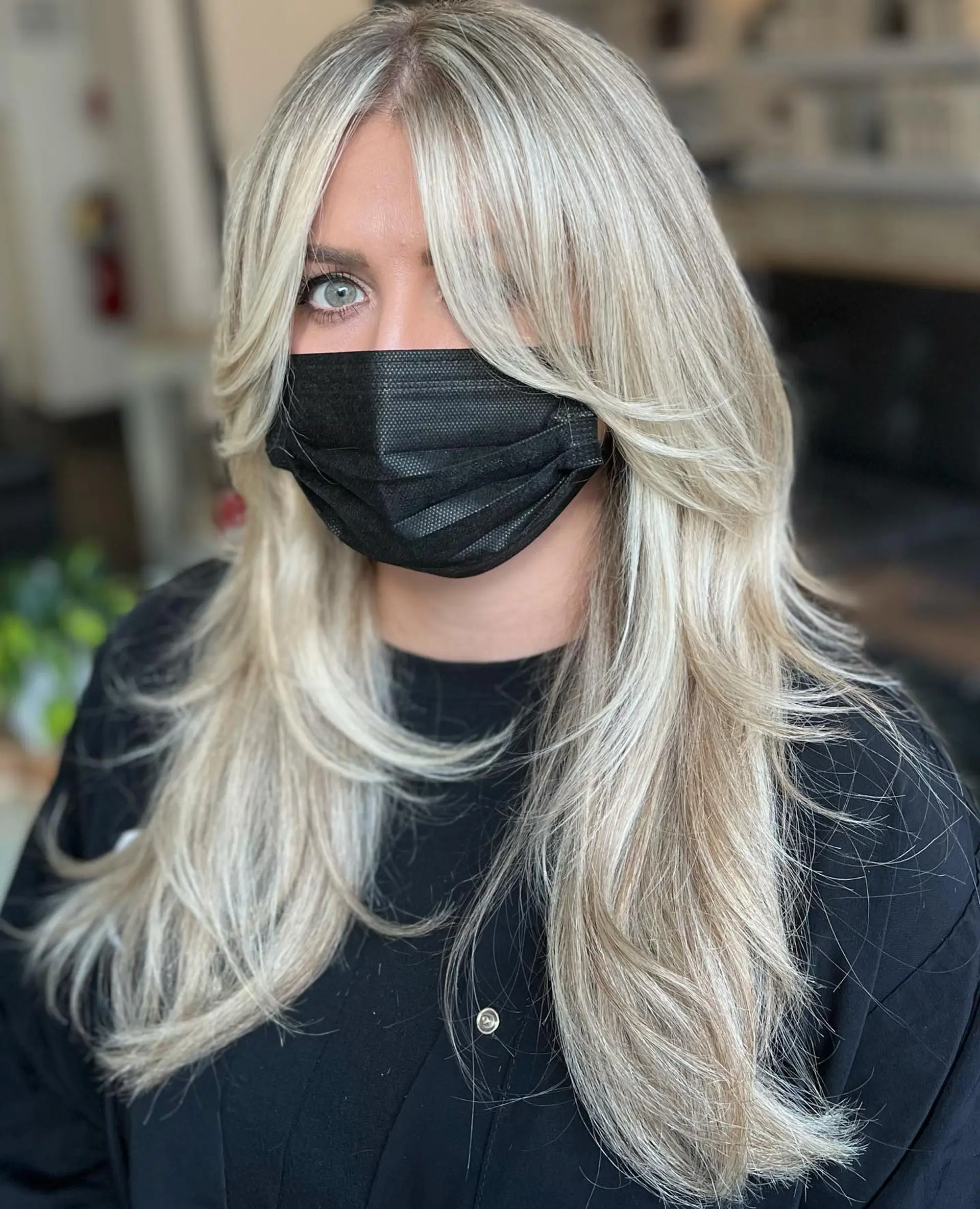 Long ash-blonde hair featuring dramatic face-framing layers and parted curtain bangs. 1