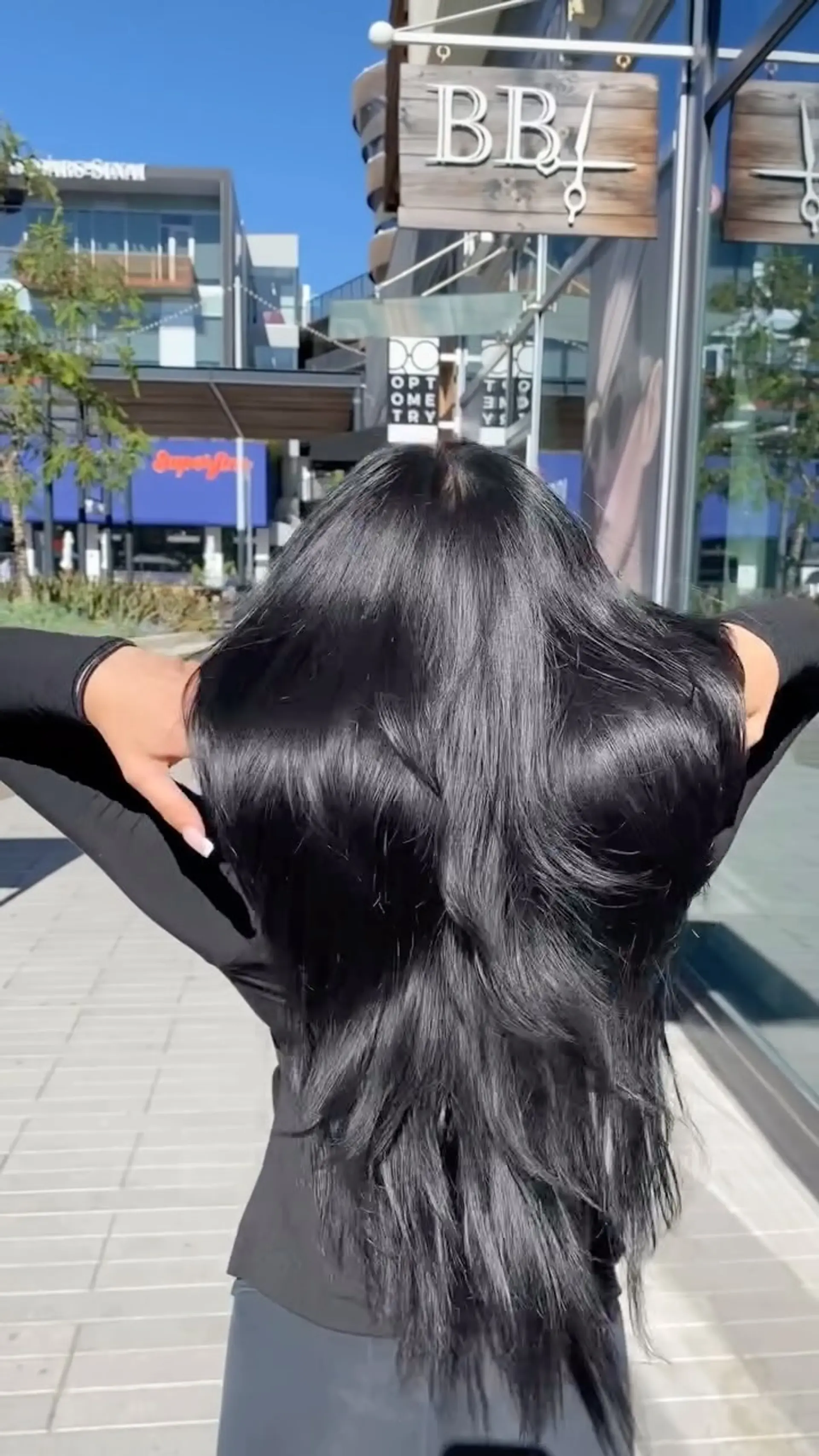Ultra-glossy, extra-long black hair cut with soft cascading layers and styled in a smooth, voluminous blowout. 1