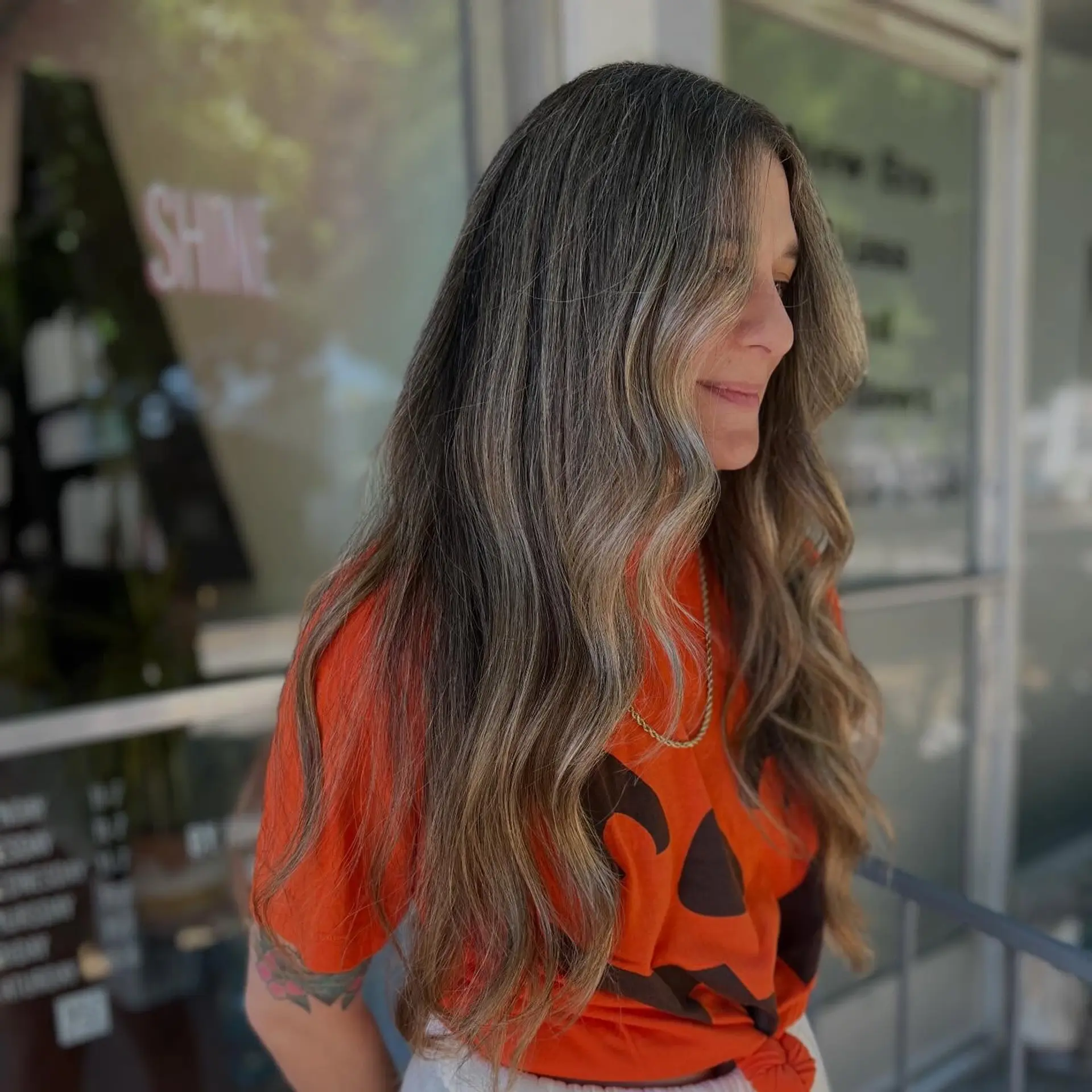 Long dimensional hair with seamless gray blending highlights styled into soft, flowing beach waves. 1