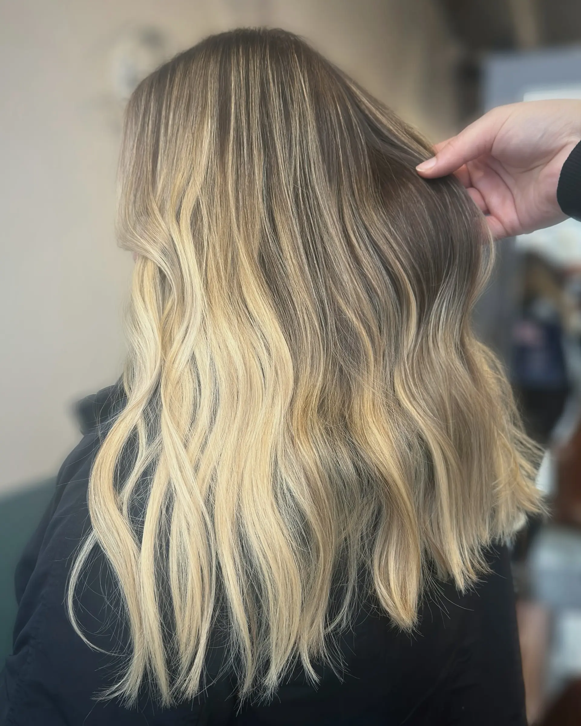 A long, wavy hairstyle with a balayage effect, blending caramel and blonde tones. 2