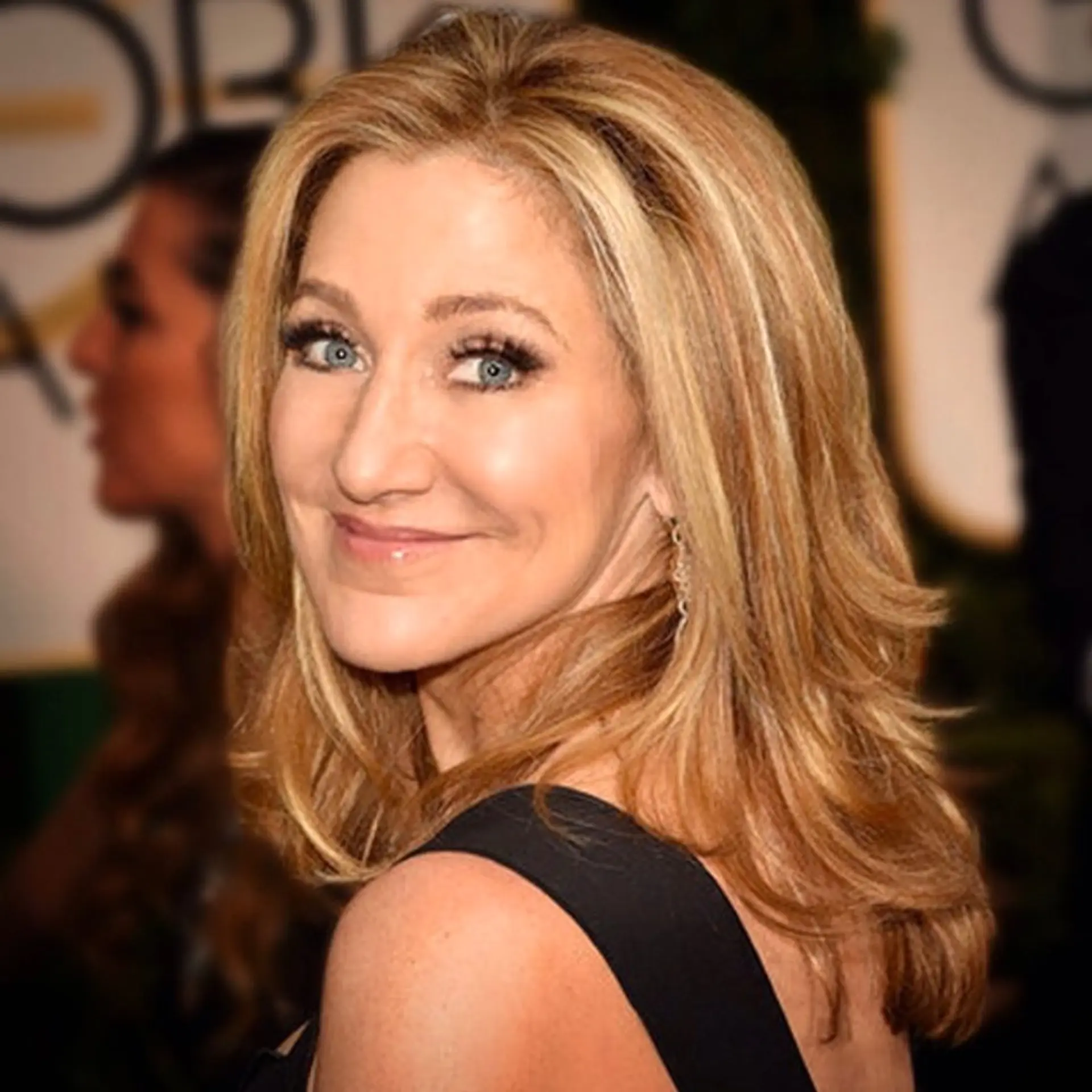 Shoulder-length golden blonde hair styled in a voluminous layered blowout with softly flipped ends. 1