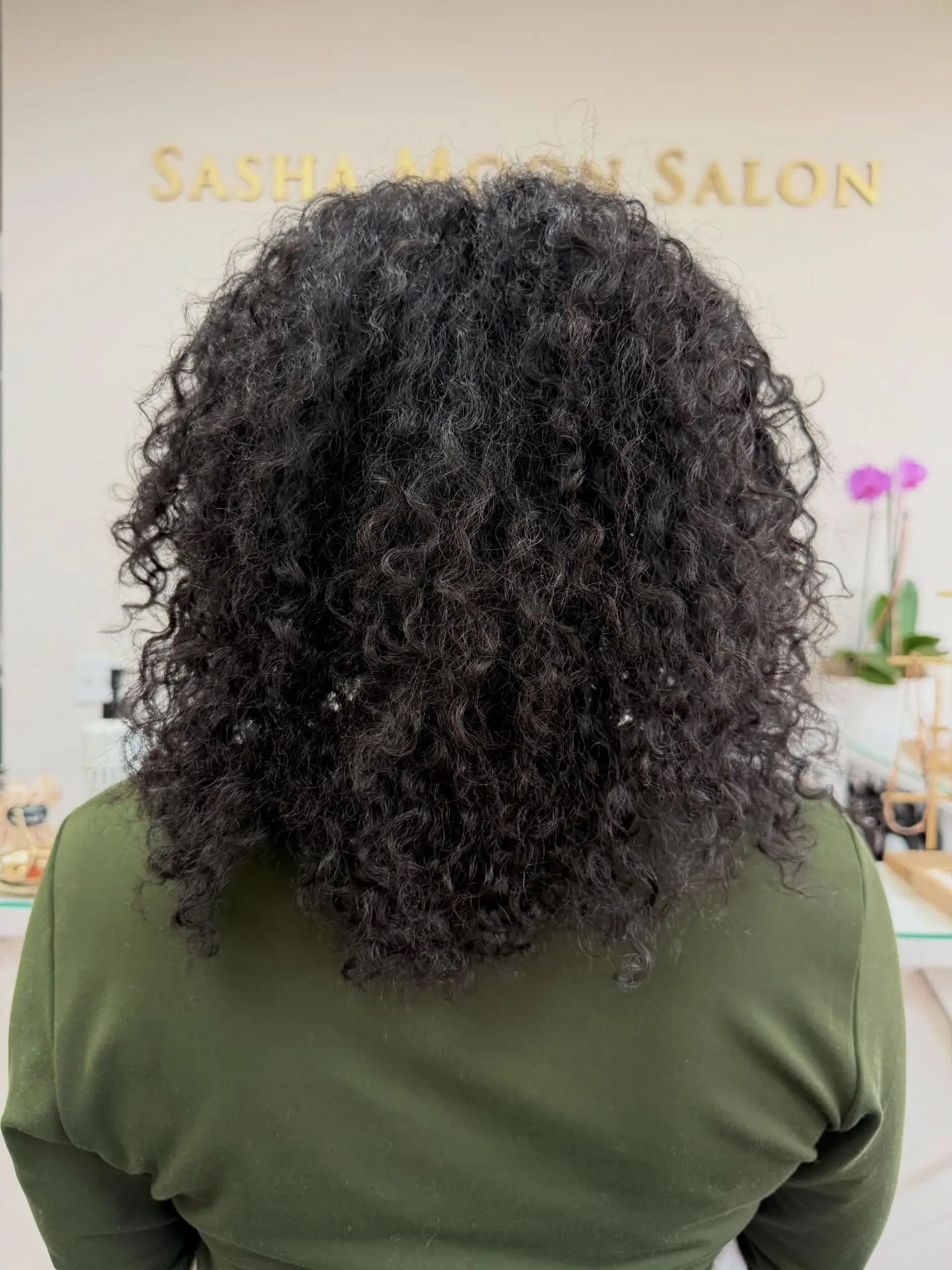 A rounded medium-length cut enhancing natural tight curls and coils with balanced volume. 1